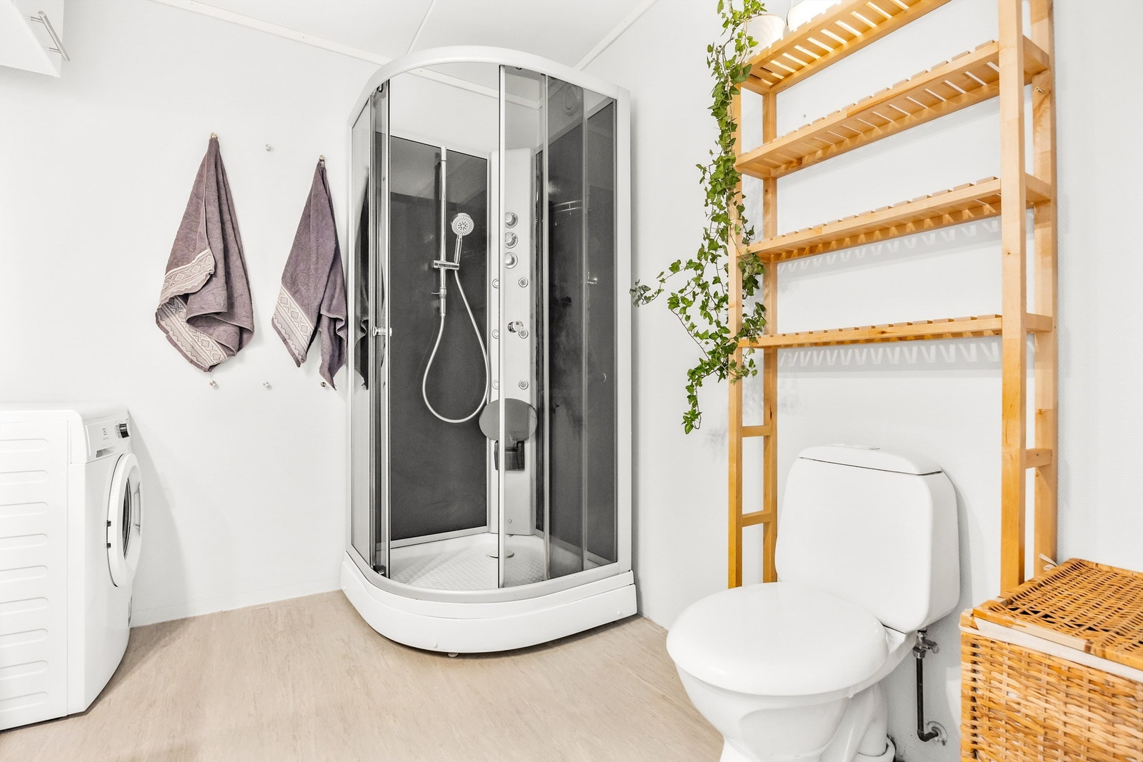 Innredet med moderne servantskap, speil med belysning, dusjkabinett med dusjarmatur og dyser, samt gulvmontert toalett. Opplegg til vaskemaskin Galleribilde