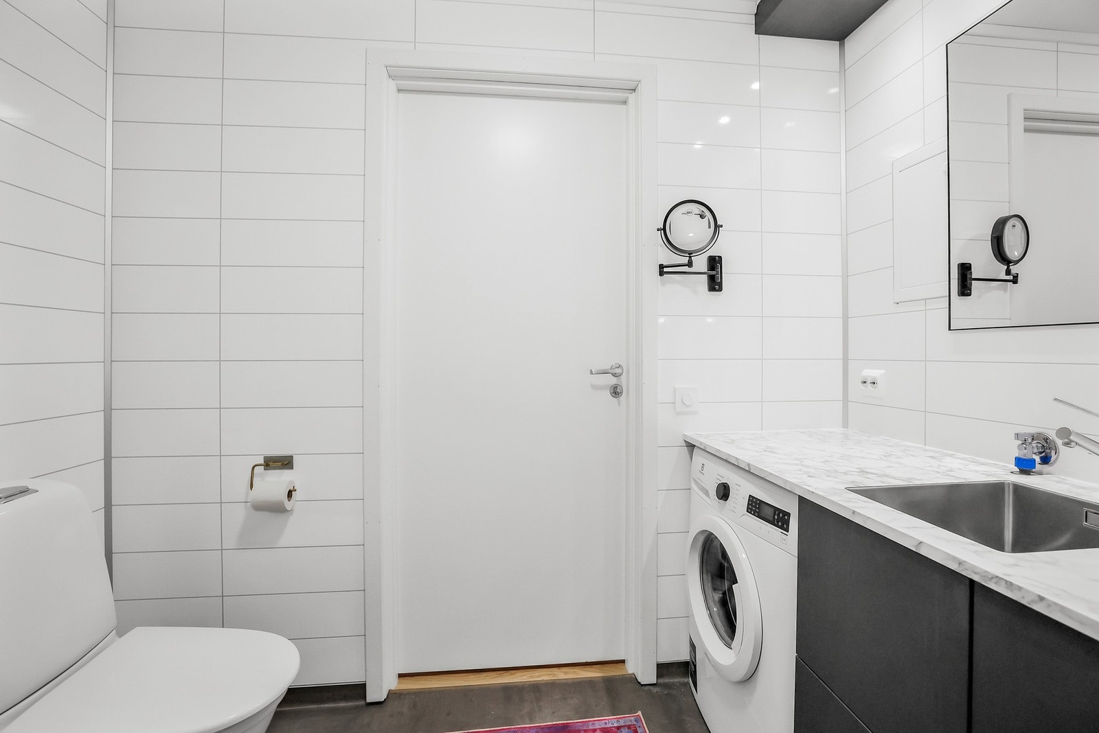 Det er gulvstående servantinnredning med speil og overlys, samt opplegg for vaskemaskin. Galleribilde
