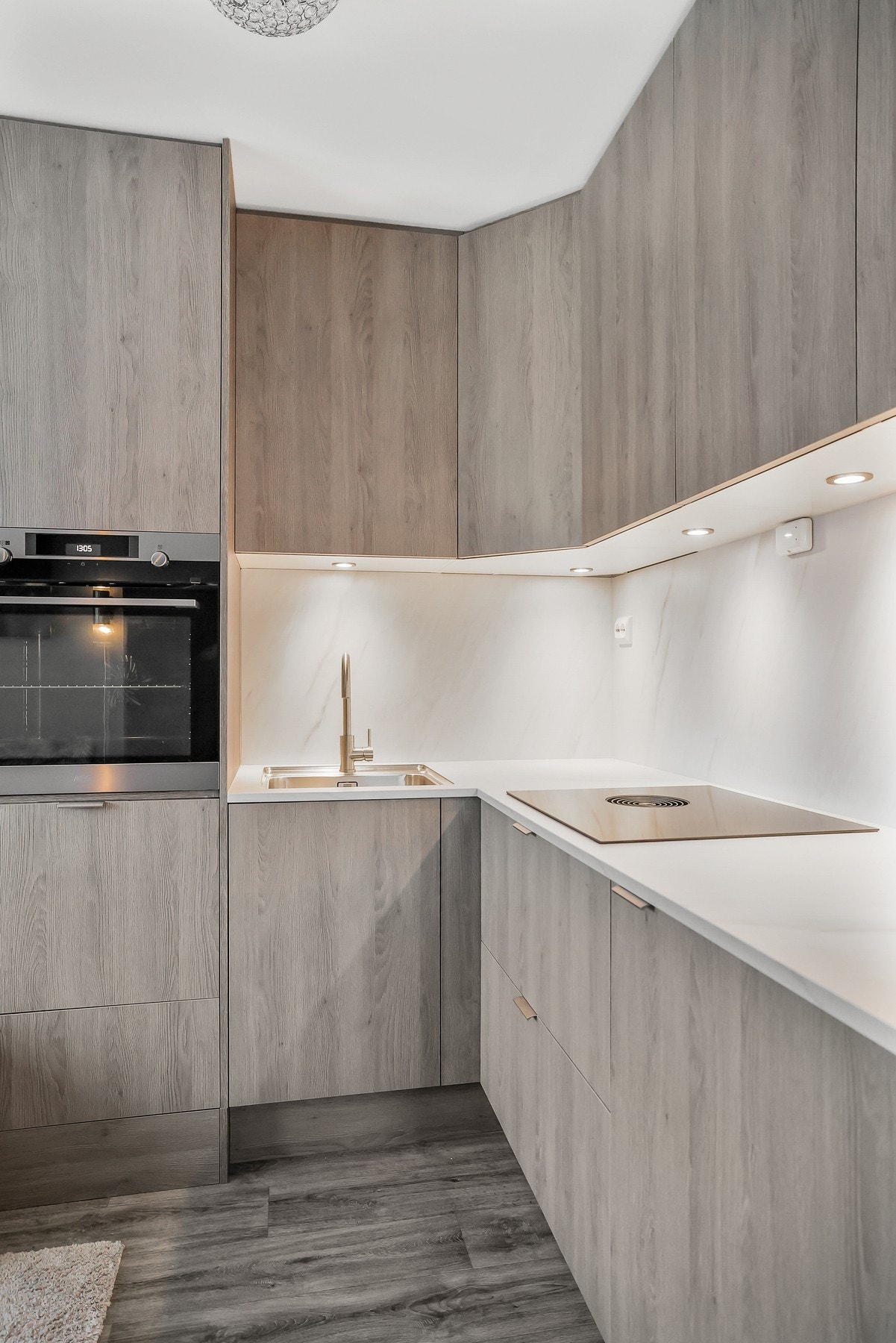 Kjøkkenet har et tidløst design med lys benkeplate av laminat og integrerte hvitevarer. Galleribilde