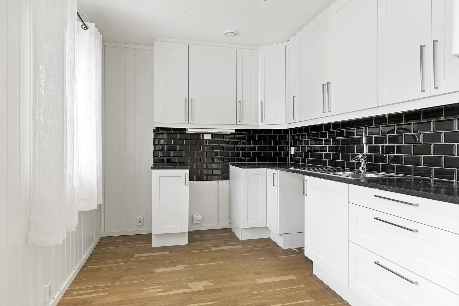 Kjøkkenet har lys innredning med glatte fronter.
Benkeplaten er av laminat. Galleribilde