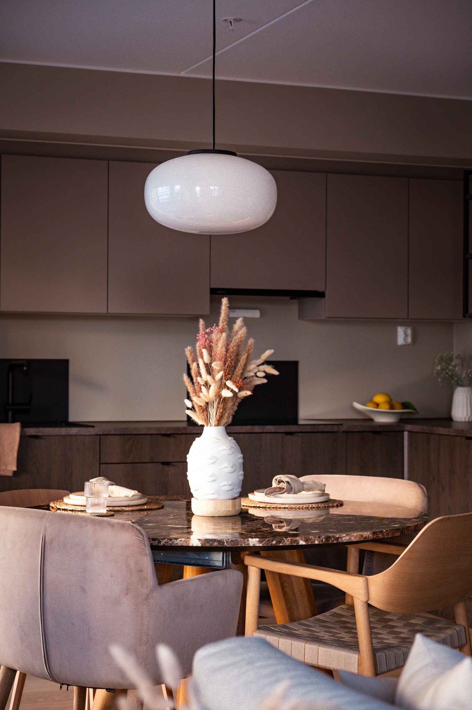 Hyggelig spisebord plassert mellom den åpne stue- og kjøkkenløsningen Galleribilde