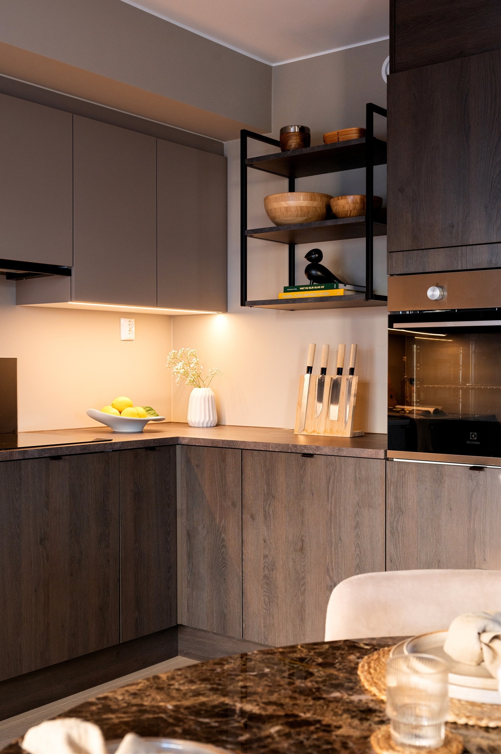 Innredning med mørke, glatte skapfronter, laminat benkeplater, nedfelt, sort oppvaskkum og ett-greps armatur Galleribilde