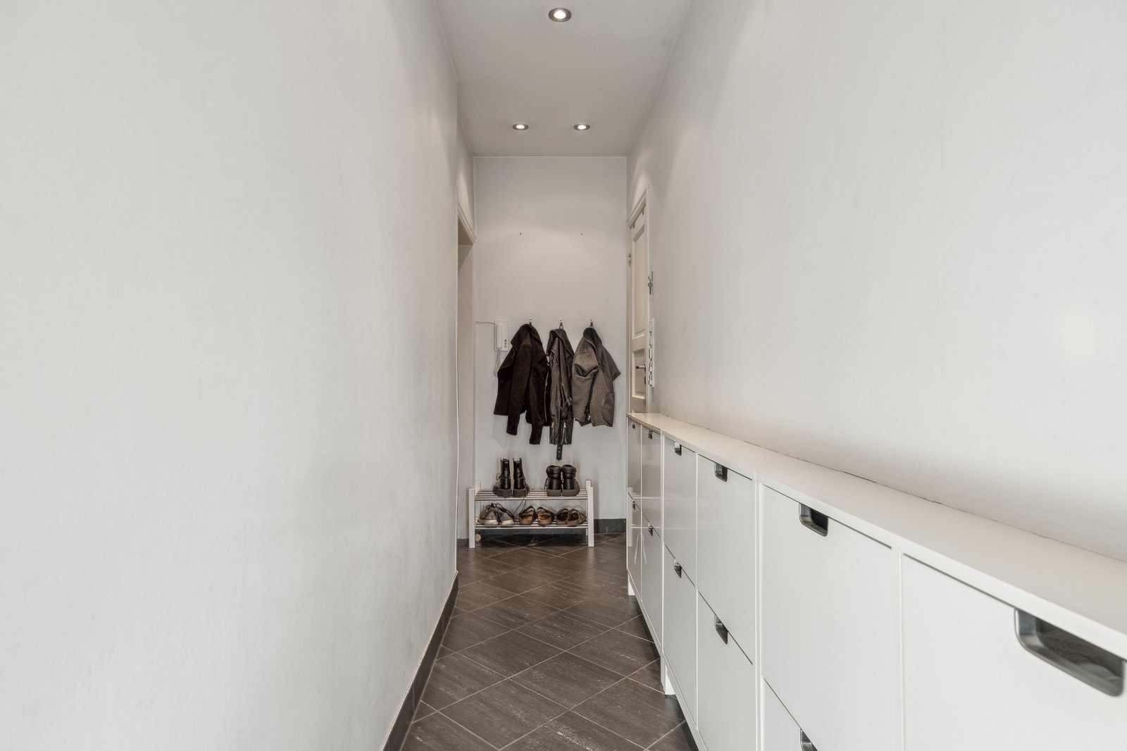 Entrè med en lang rad av skohyller. Det er også oppheng til yttertøy. Galleribilde