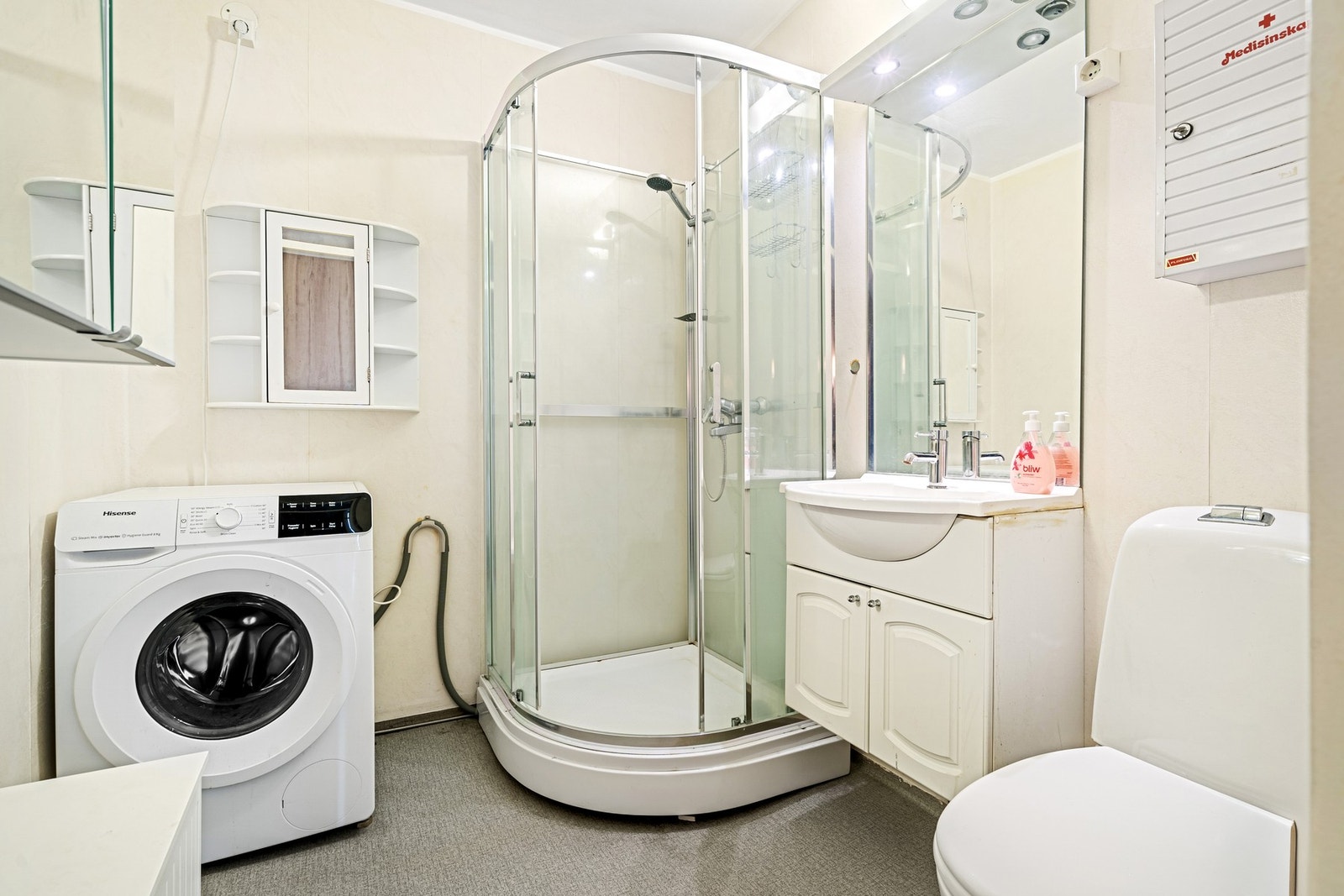 Badet er utstyrt med dusjkabinett, servant i skap og toalett. Galleribilde