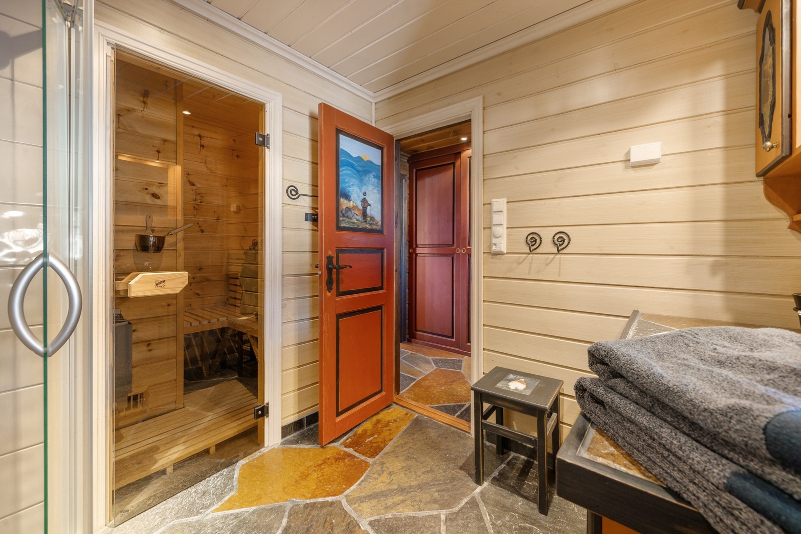 Bad med varmekabler i skifergulv, wc, dusjhjørne, servant med skap under. Inngang badstue. Galleribilde