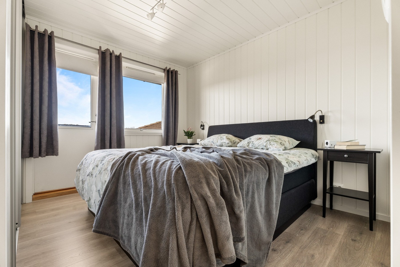Boligen har to soverom i første etasje, med 1-stavs laminatgulv og hvitmalte panelplater for en behagelig atmosfære. Galleribilde