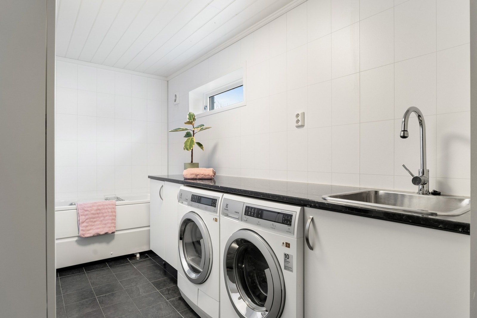 Våtrommet nede er et kombinert bad/vaskerom med samme type overflater som hovedbadet. Galleribilde