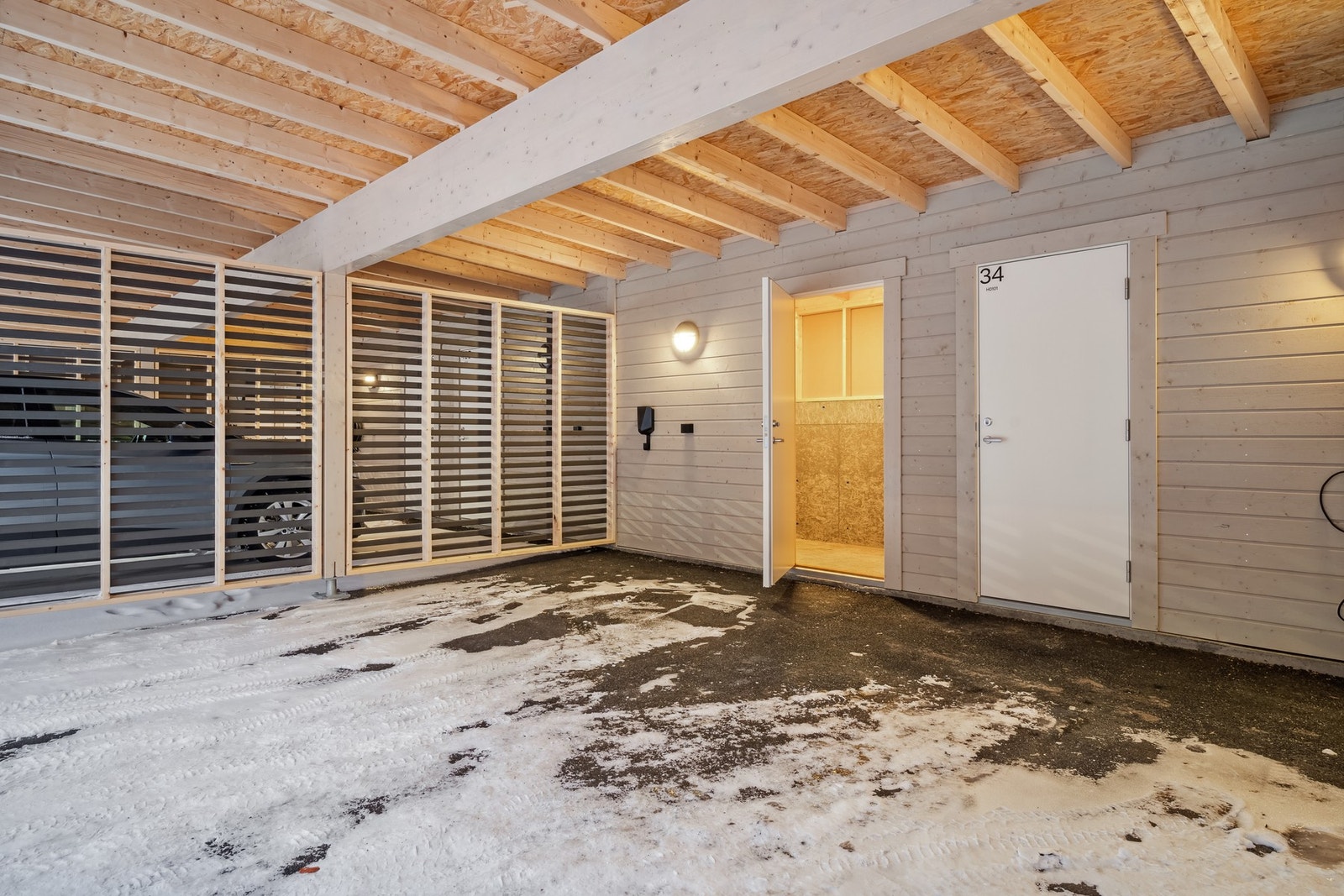 Leiligheten disponerer en carport med elbil lader, uttak til motorvarmer og utebod Galleribilde