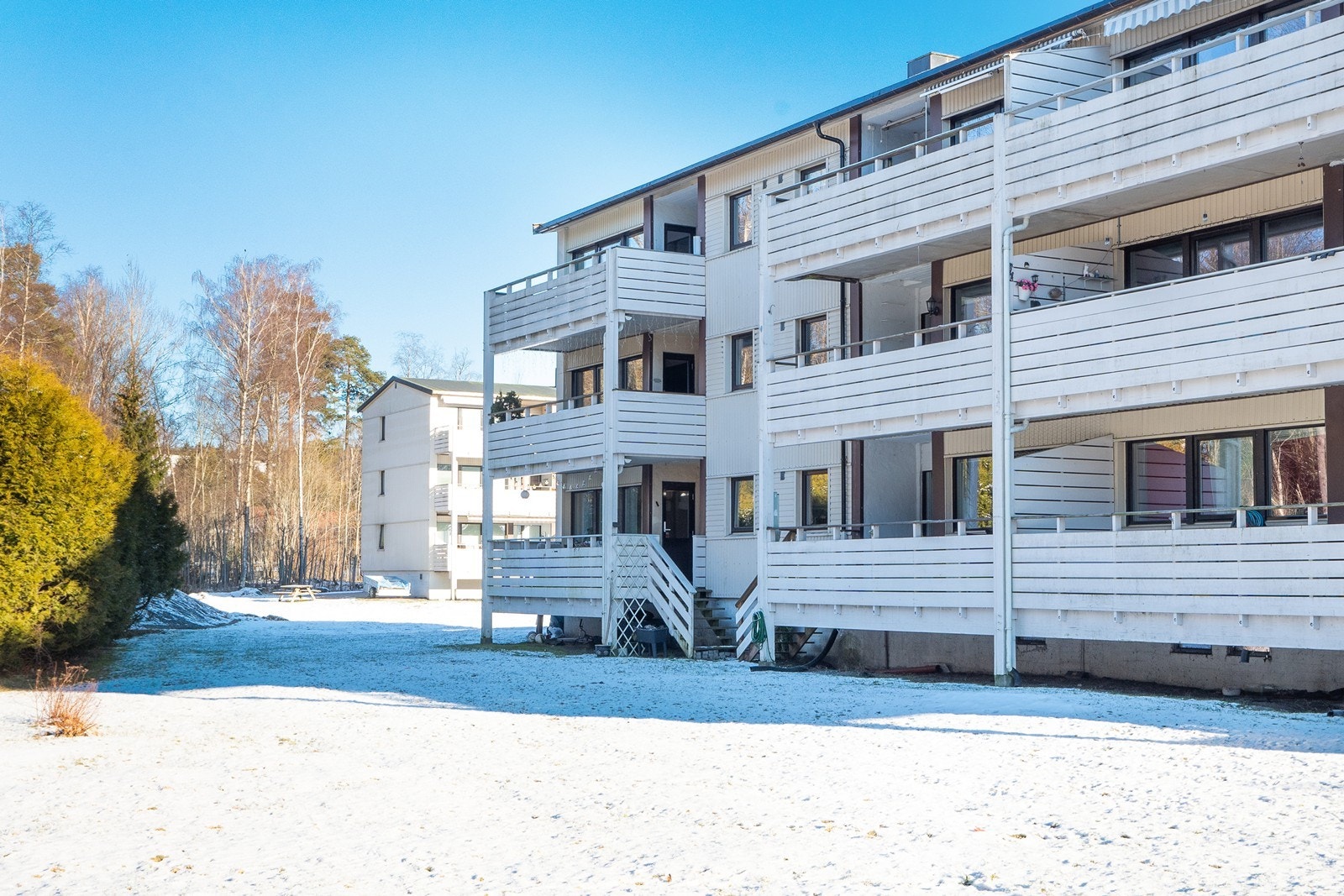 Beliggenheten i ende gir en skjermet og samtidig åpen uteplass med trapp ned til fellesområde med gressplen og beplantning. Galleribilde