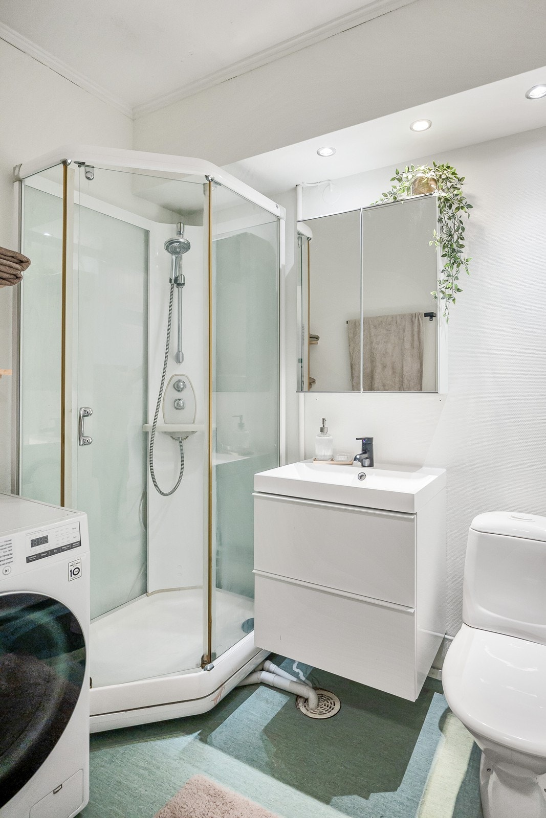 Badet har varmekabler i gulv, nedfelt downlights i del av rommet, opplegg for vaskemaskin og delvis innredning fra 2024. Galleribilde