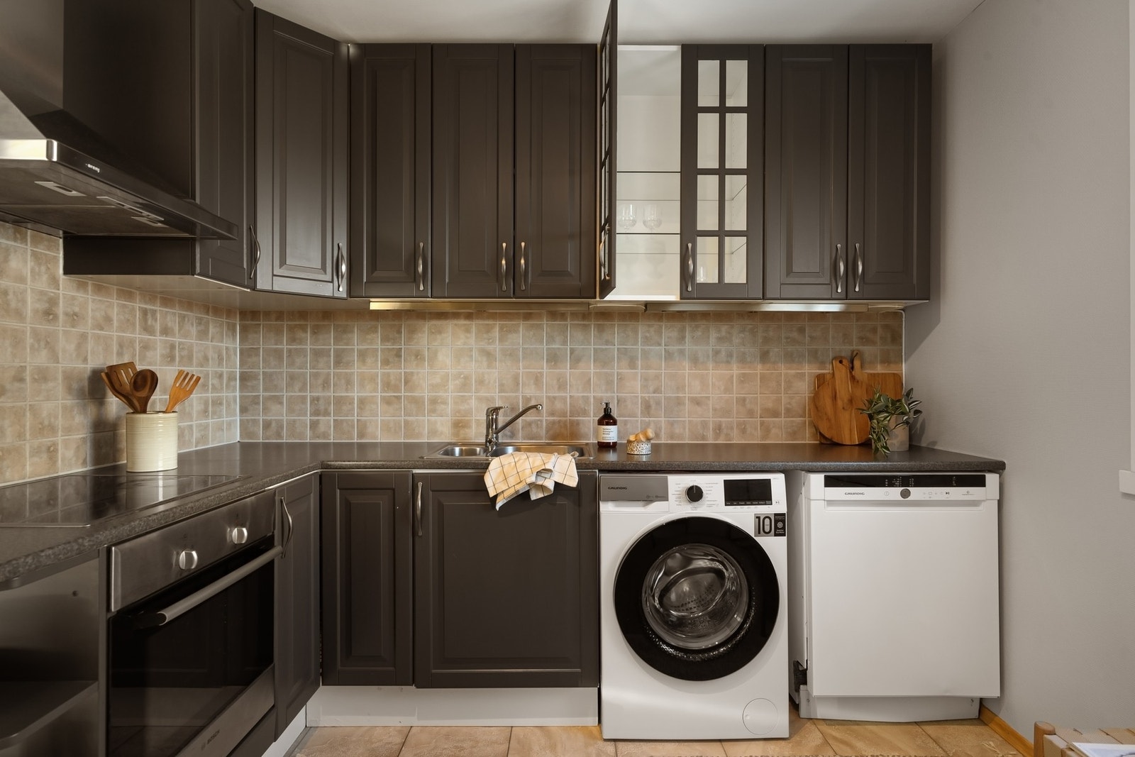 Det er fliser mellom over- og underskap, og benkeplaten er av laminat. Galleribilde