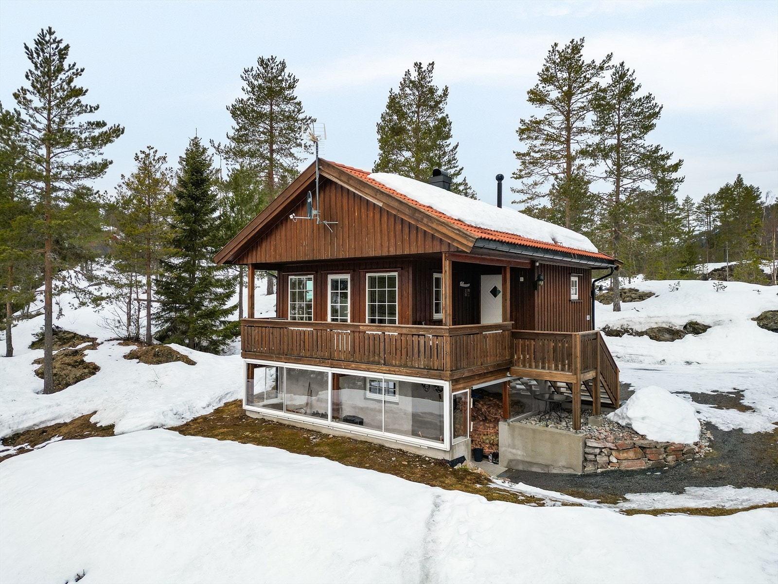 Hytta har en flott og overbygget veranda på 12 kvm. Verandaen strekker seg fra inngangspartiet, rundt hushjørnet og langs hyttas fasade. Under verandaen er det en innglasset lagringsplass. Galleribilde