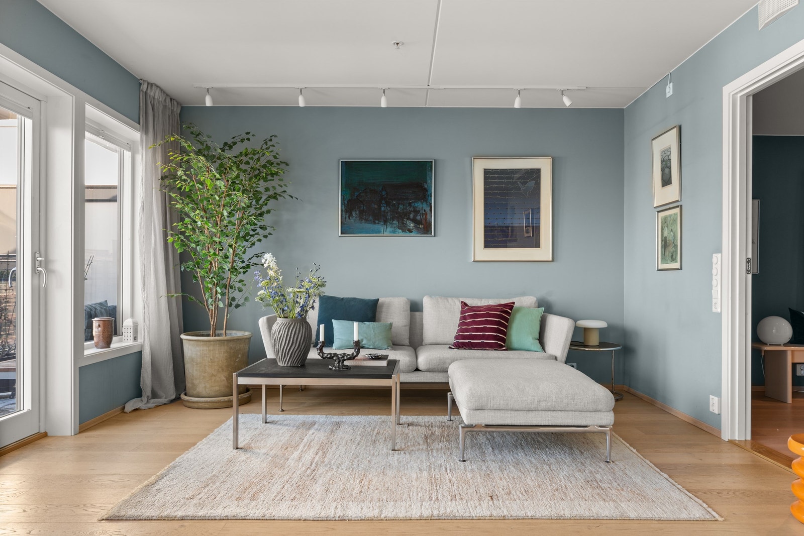 Det er store vindusflater som slipper inn rikelig med lys og som bidrar til å skape en luftig følelse i leiligheten. Vinduene har både innvendig og utvendig solskjerming. Galleribilde