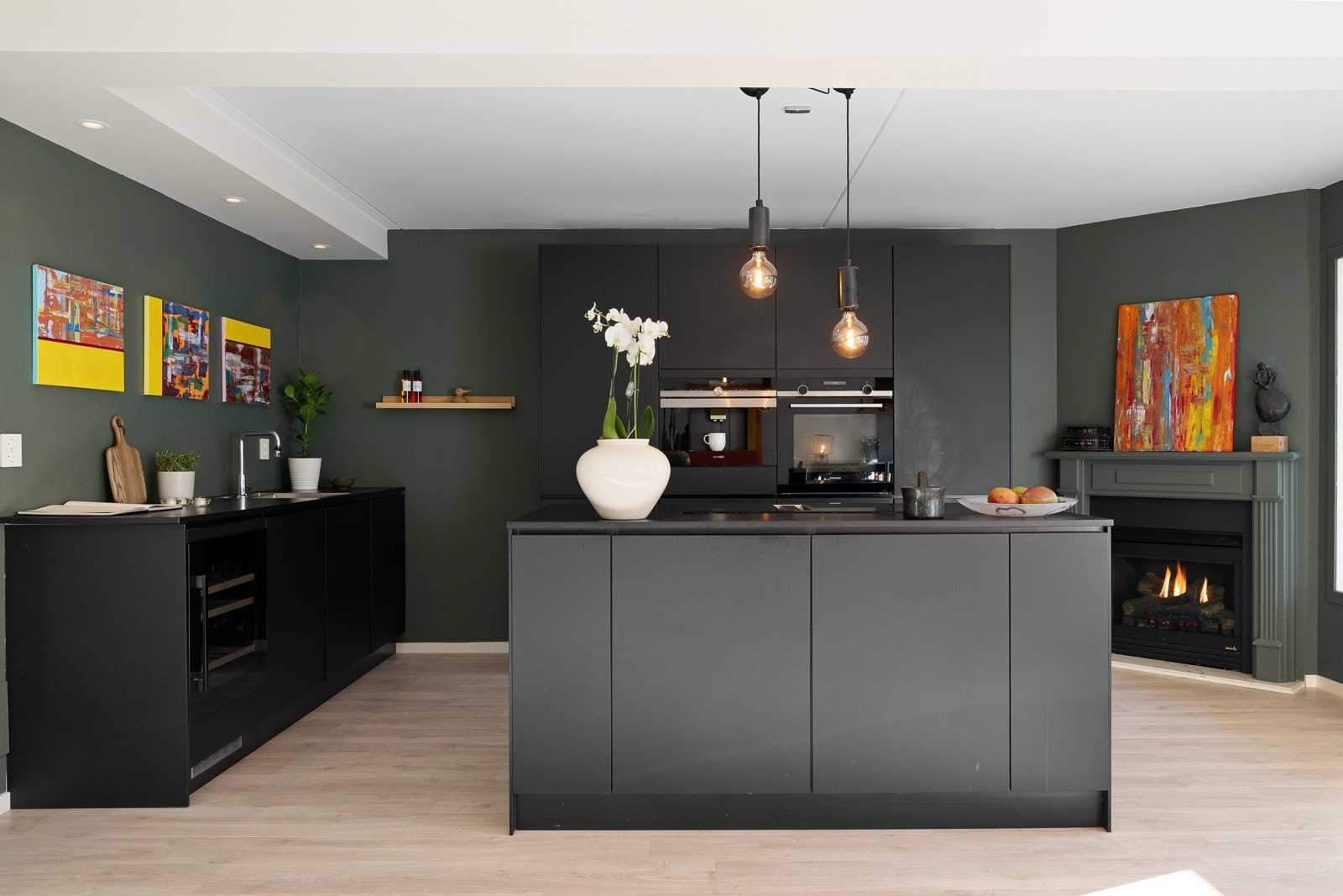 Stilrent og funksjonelt kjøkken med mørke, slette fronter og en elegant mørk laminat benkeplate. Galleribilde
