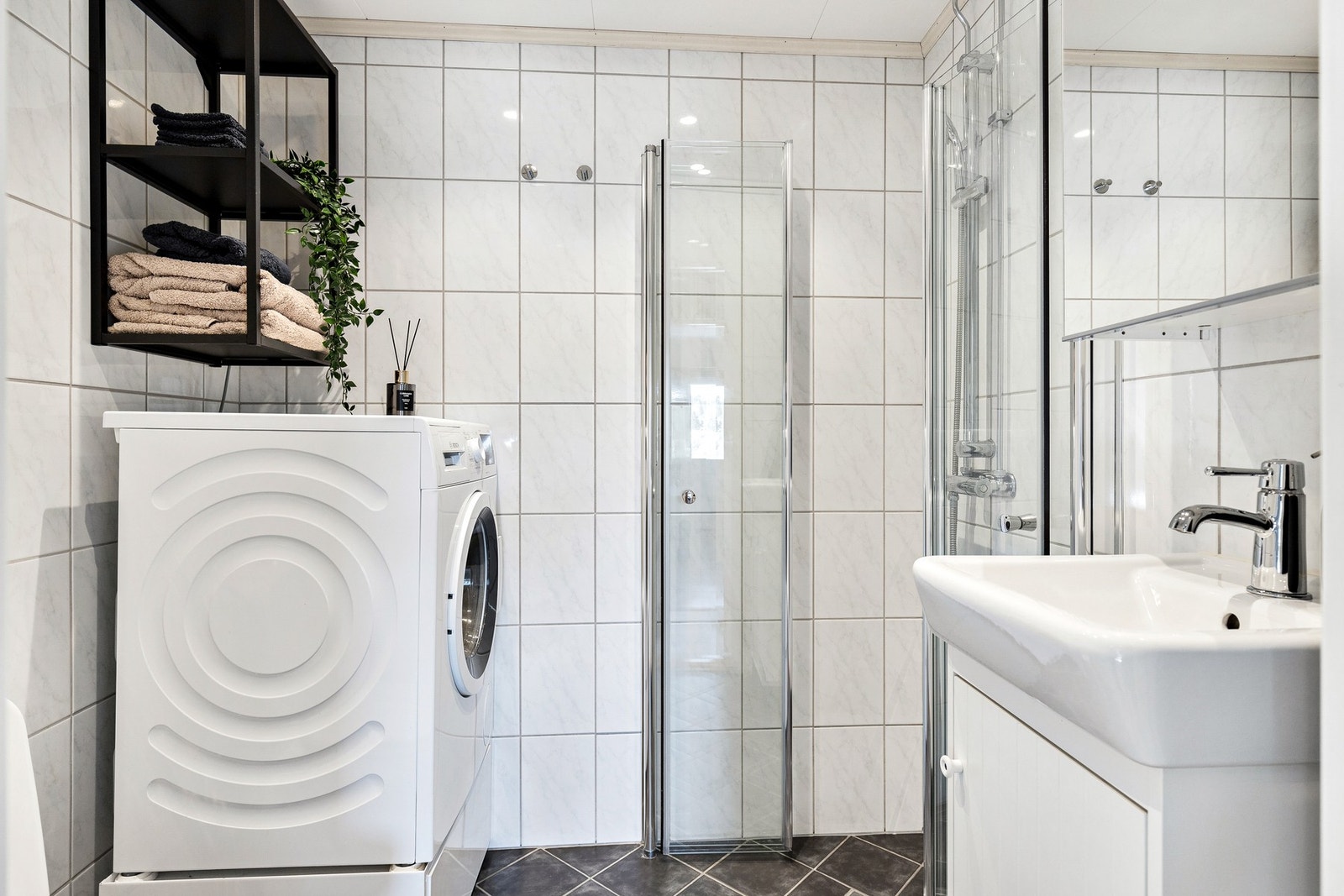 Innredet med servant og speil, dusjnisje med innfellbare glassdører og gulvmontert toalett. Det er også opplegg for vaskemaskin (vaskemaskin følger i utgangspunkt ikke med ved handelen). Galleribilde