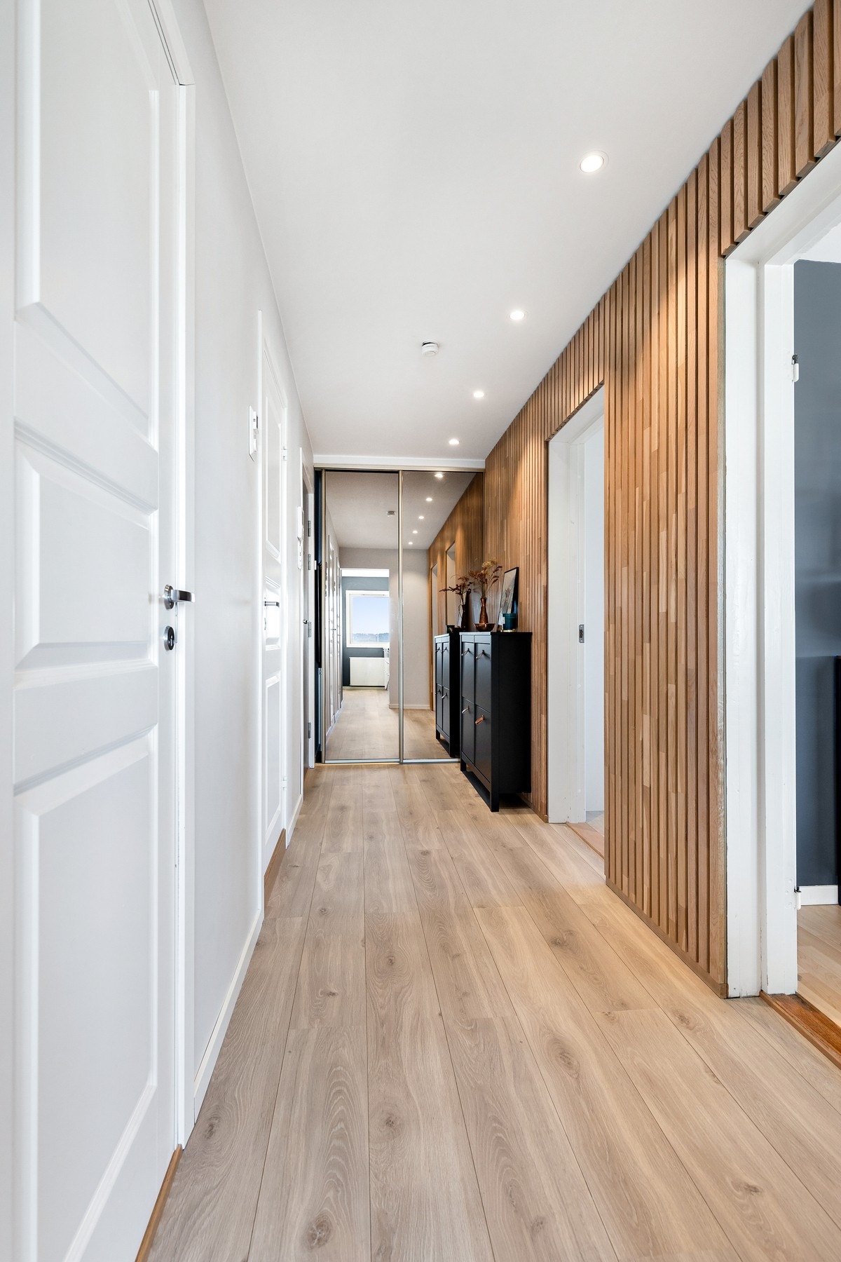 Velkommen inn! Entréen er lys og romslig, med en moderne spilevegg som gir et innbydende og stilfullt førsteinntrykk. Galleribilde