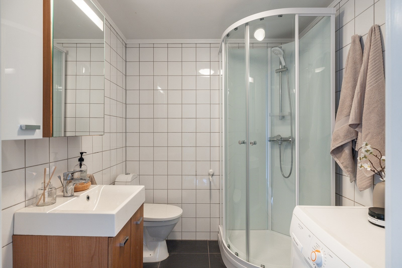 Badet består av servant, speilskap, toalett og dusjkabinett. Man har opplegg/plass til vaskemaskin. Galleribilde