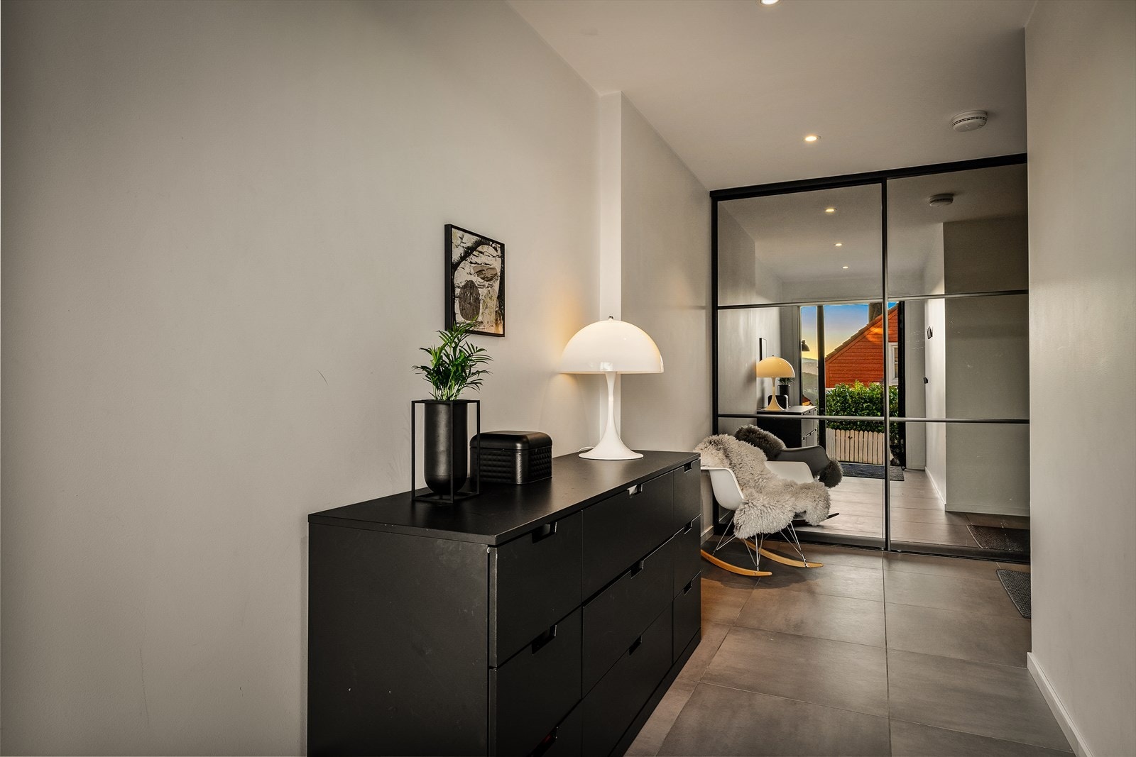 Du blir møtt av en romslig og innbydende entré/hall, utstyrt med en skyvedørsgarderobe med speilfronter. Allerede her vil du merke de høye kvalitetsstandardene, med moderne og stilige overflater som går igjen i hele boligen Galleribilde