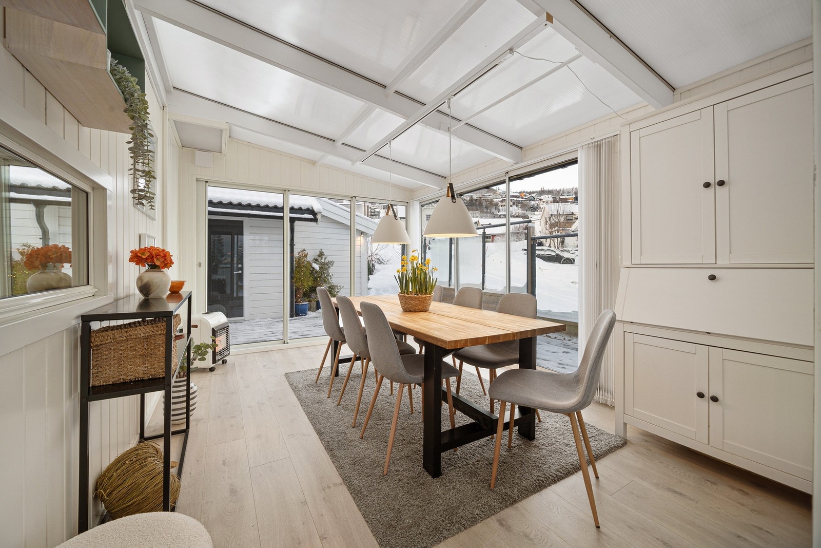 Vinterhagen deler seg i spisesone og en sone med en sittegruppe Galleribilde