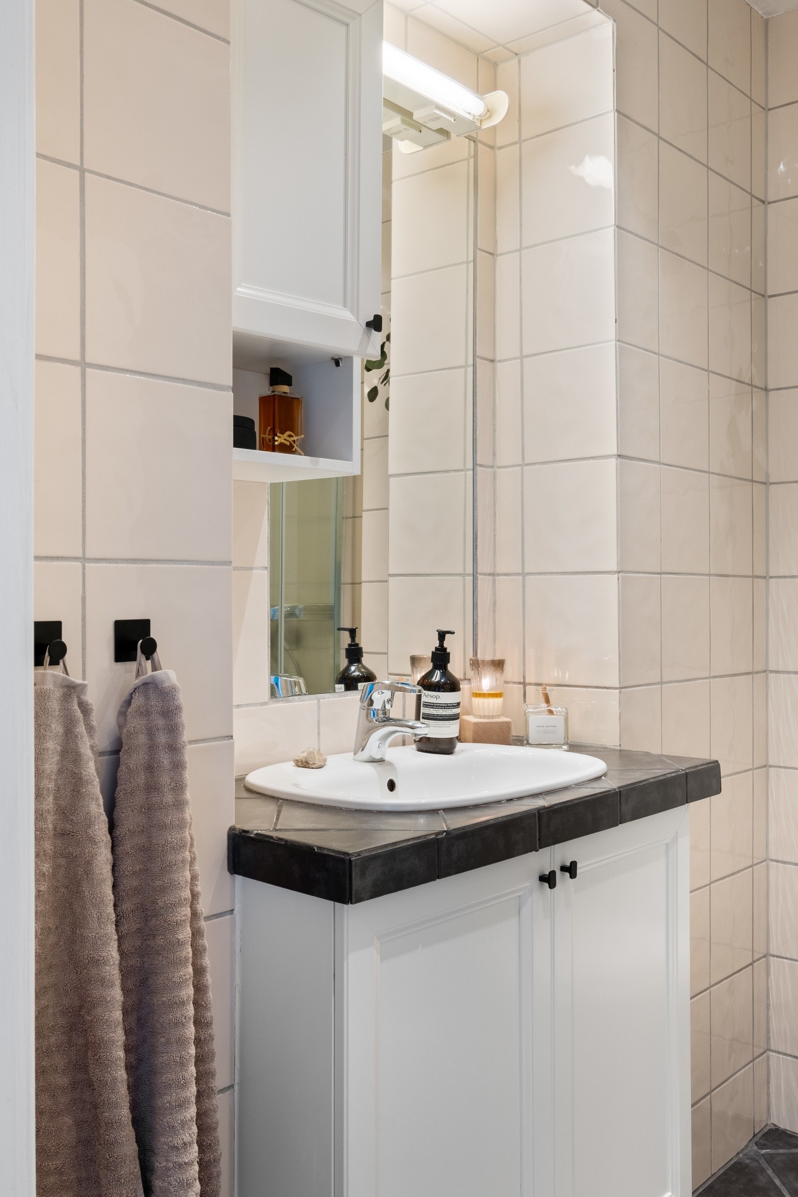 Baderomsmøbelet har flislagt topp som matcher gulvflisene. Galleribilde