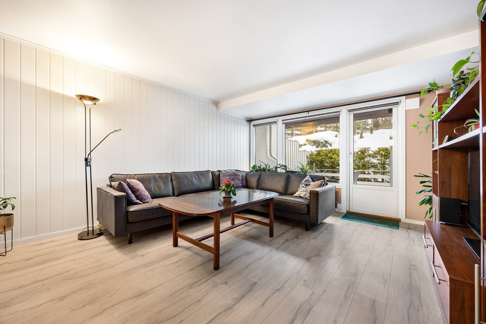 Stor og trivelig stue med pen kontrastvegg og naturlige møbleringssoner. Galleribilde