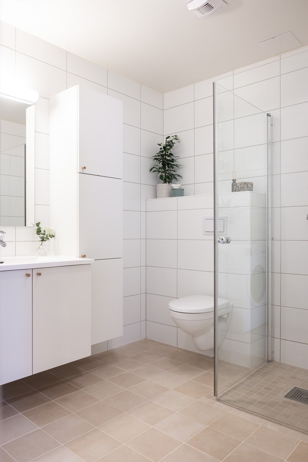 Badet består av vegghengt servantskap, sideskap og speil, dusjhjørne med innadslående dusjdører og vegghengt toalett. Galleribilde