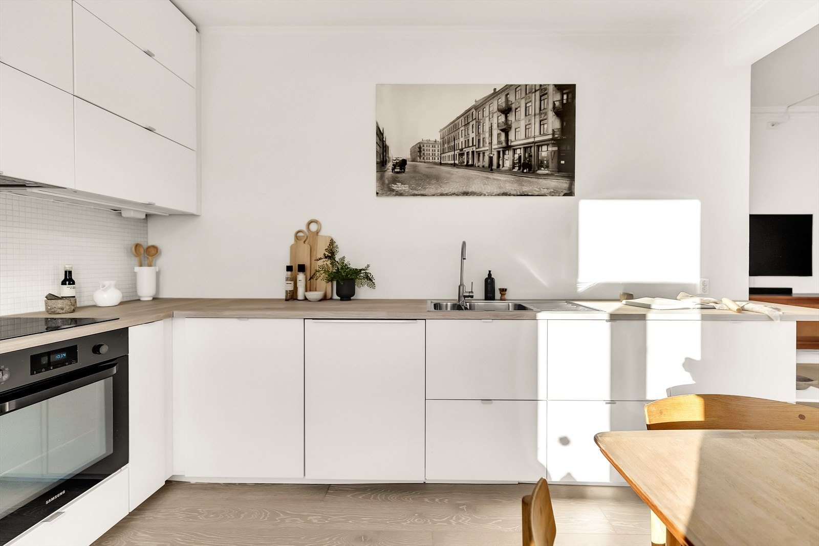 Kjøkkenet er utstyrt med en heltre benkeplate som gir et varmt og naturlig preg, og praktiske fliser over benkeplaten. De integrerte hvitevarene er stekeovn, oppvaskmaskin, kjøleskuff og fryser, samt en kjøkkenvifte med omluft. Galleribilde