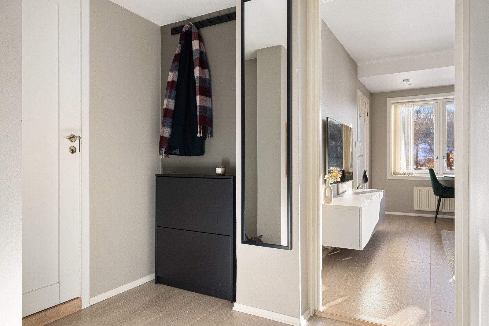 Hyggelig entré som gir et godt førsteinntrykk og er innredet med en knaggrekke og skoskap som gir en praktisk løsning for oppbevaring av yttertøy og sko Galleribilde