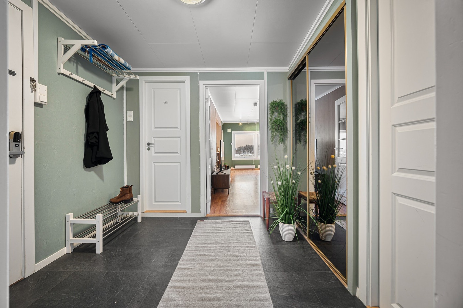Entréen har god plass, og det er både skyvedørsgarderobe og oppheng for yttertøy på knagger Galleribilde
