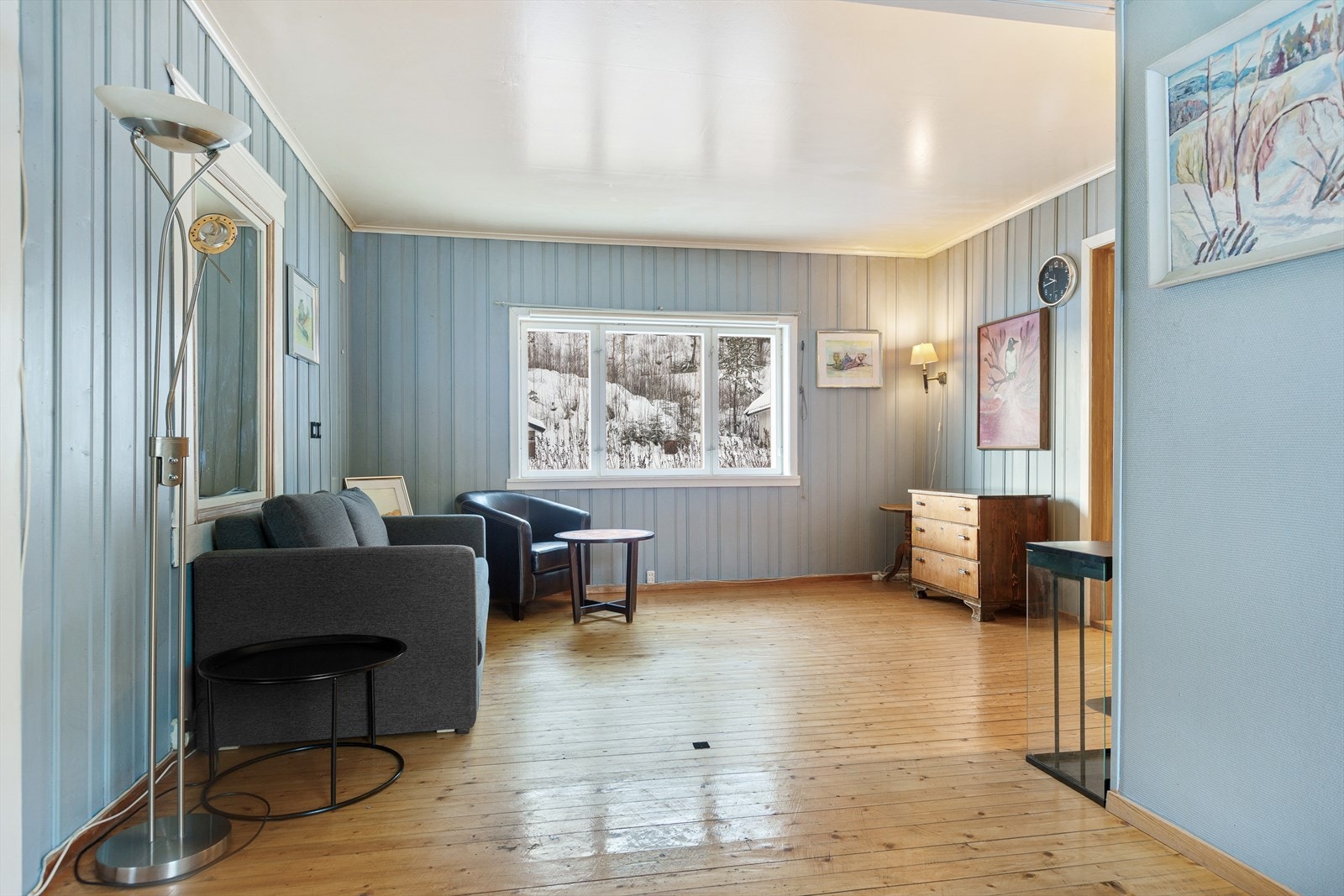 Stua har tregulv og vegger kledd med malt trepanel, og kan møbleres etter eget ønske. Galleribilde