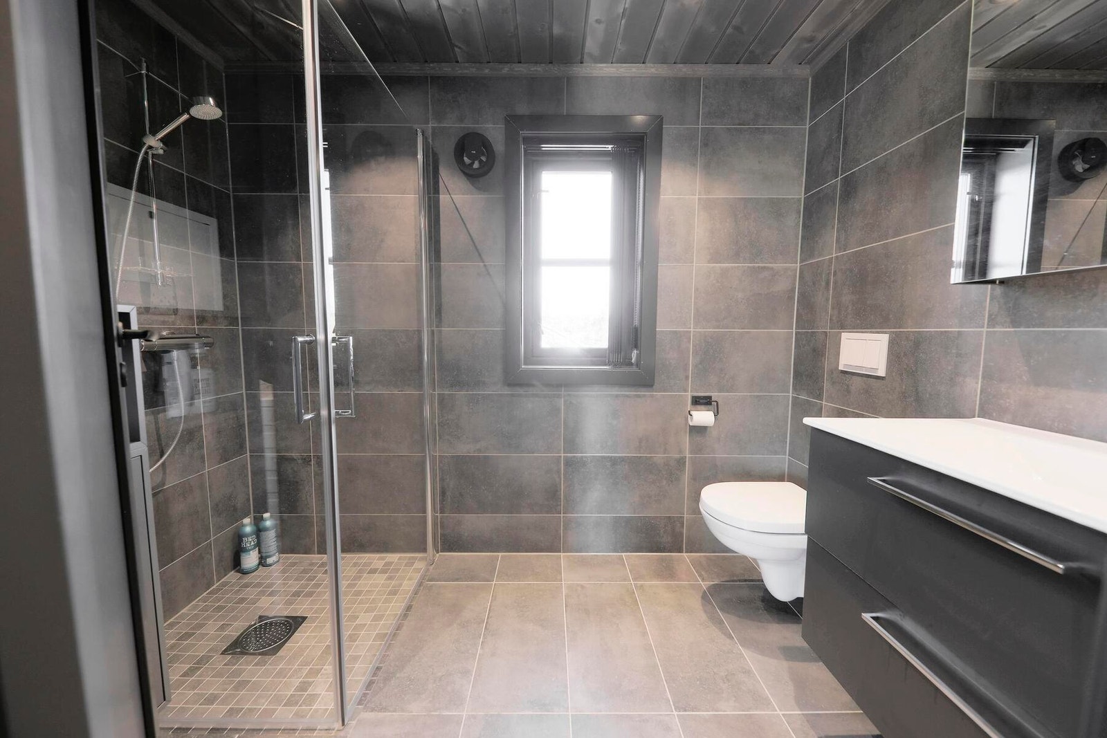 Delikat bad med flislagte overflater og varmekabler i gulv. Foto fra en oppsatt hytte Galleribilde