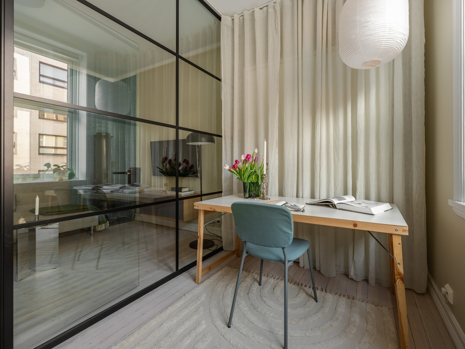 I stedet for gipsvegger er det satt opp glassvegger med smijernsdetaljer for å slippe inn lys i oppholdsrommet. Gardinene kan skyves foran glasset når skapsengen er i bruk. Galleribilde