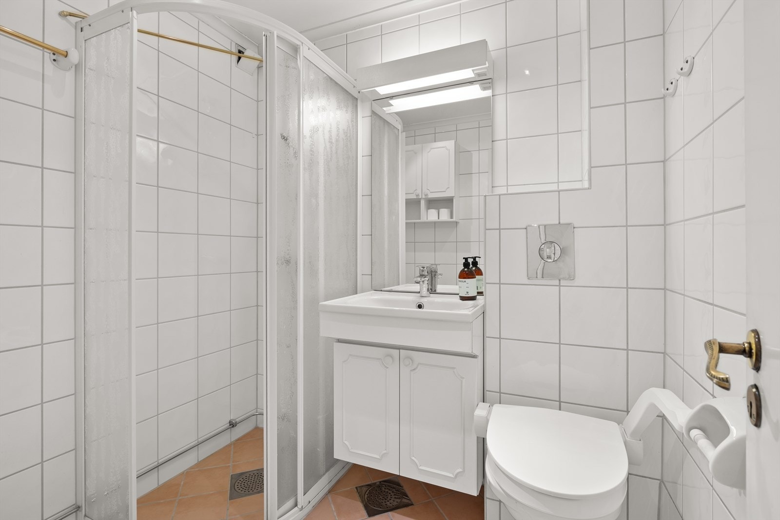 Lyst flislagt baderom pusset opp i 2003 i regi av borettslaget. Badet har opplegg for vaskemaskin, varmekabler på gulv, servant med oppbevaring, toalett og praktisk dusjhjørne Galleribilde