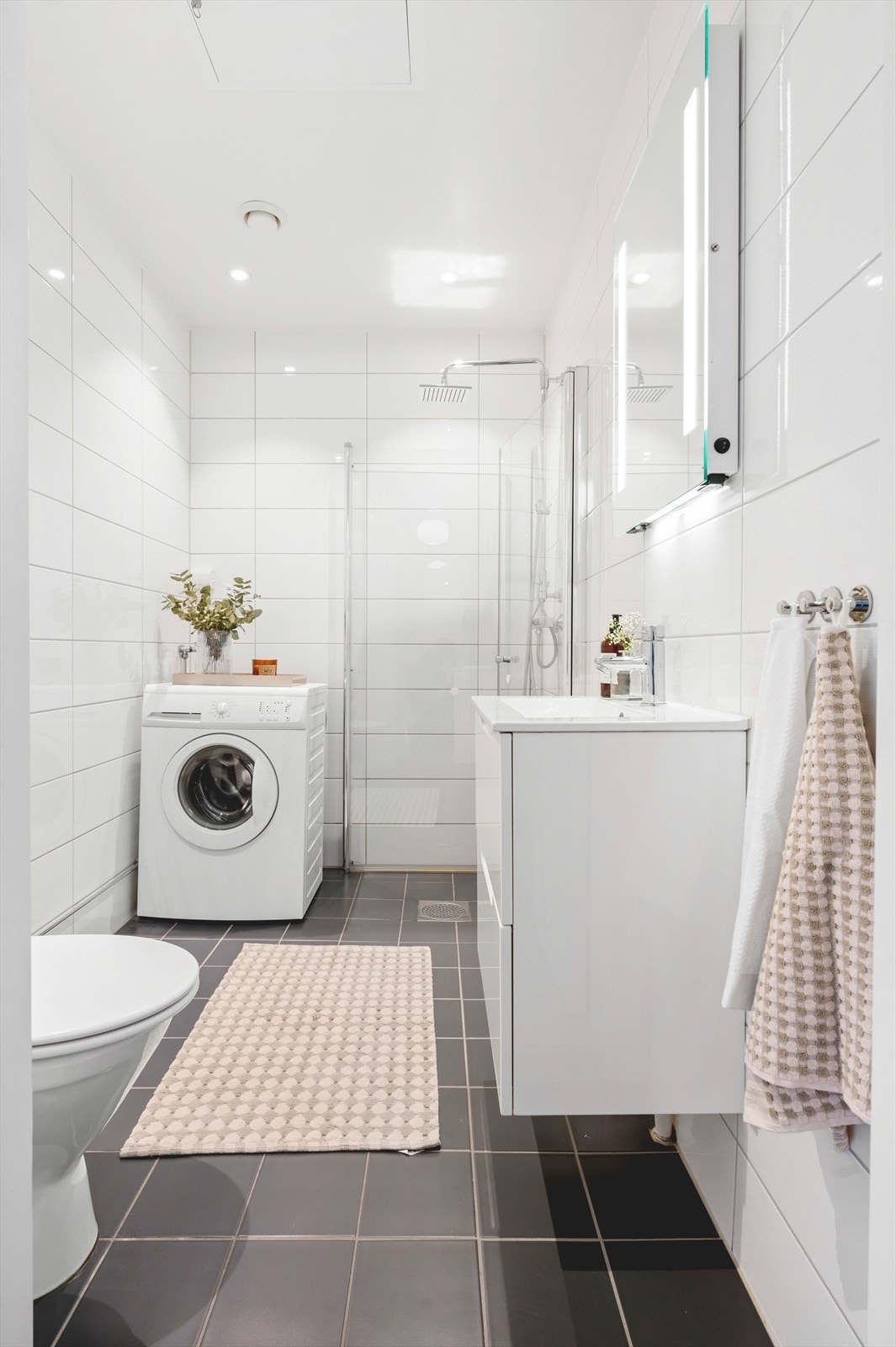 Innredningen består av servant med innredning, speil med lys over servant, gulvstående toalett og dusjhjørne med svingbare glassdører. Opplegg for vaskemaskin og balansert ventilasjon. Galleribilde