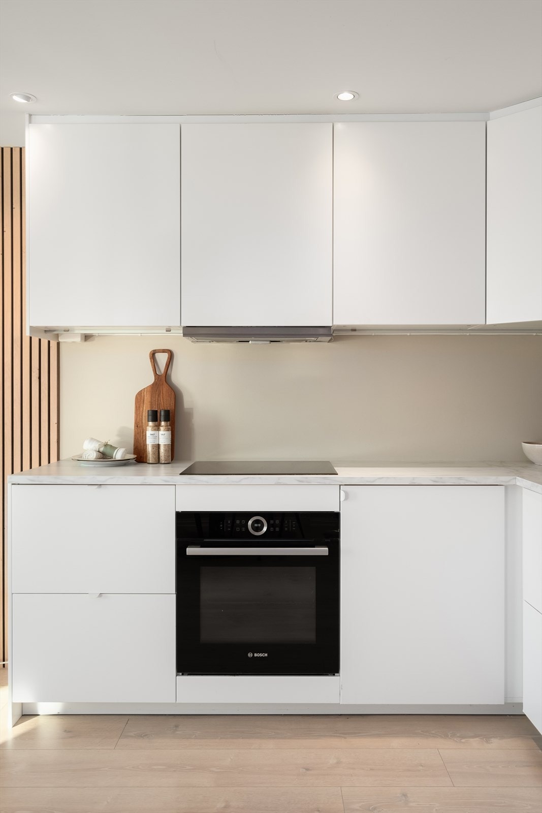 Kjøkkeninnredning med hvite, slette fronter og integrerte hvitevarer Galleribilde