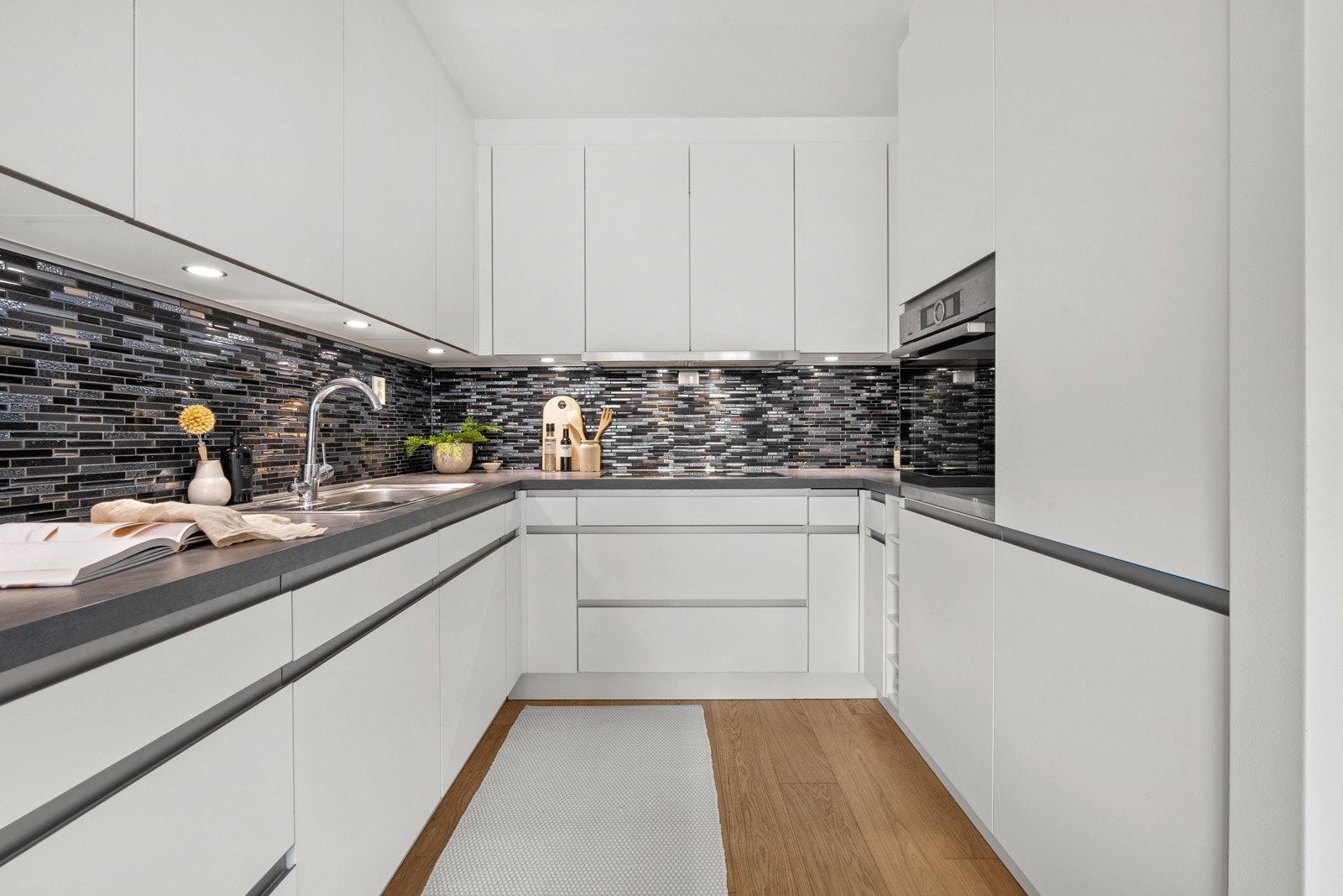 Induksjonstopp, stekeovn, oppvaskmaskin, kjøle/fryseskap og ventilator er integrert i innredningen. Galleribilde