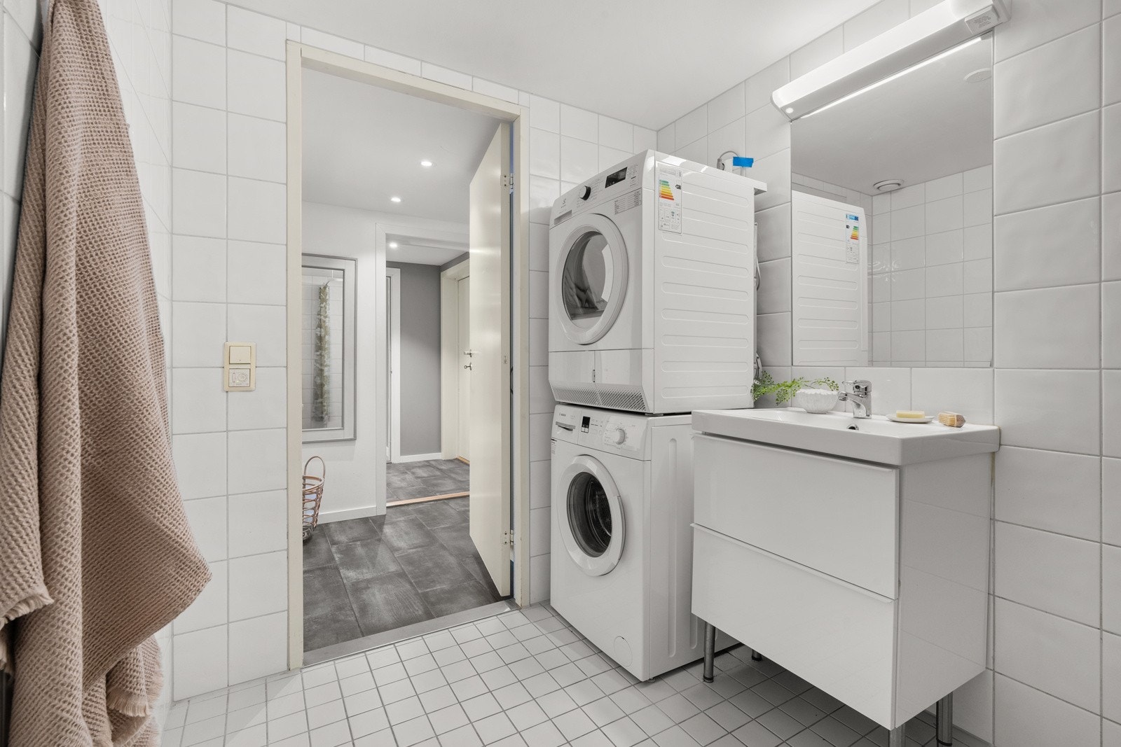 Badet i hybelen er utstyrt med både vaskemaskin og tørketrommel. Videre er det heldekkende servant med skuffer og lys over speil. Galleribilde