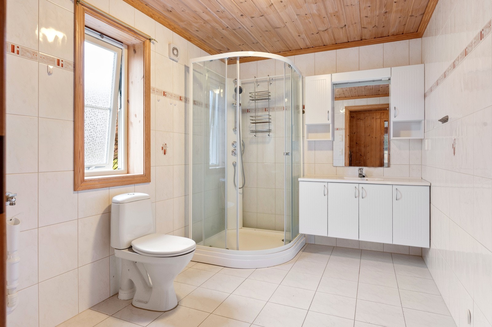 Badet er innredet med servantskap med god lagringsplass, dusjkabinett og wc. Galleribilde