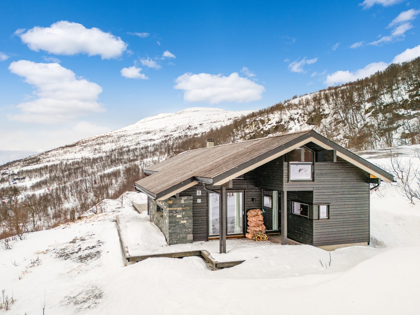 På fremsiden har hytten en lekker fasade med natursteinsforblending Galleribilde