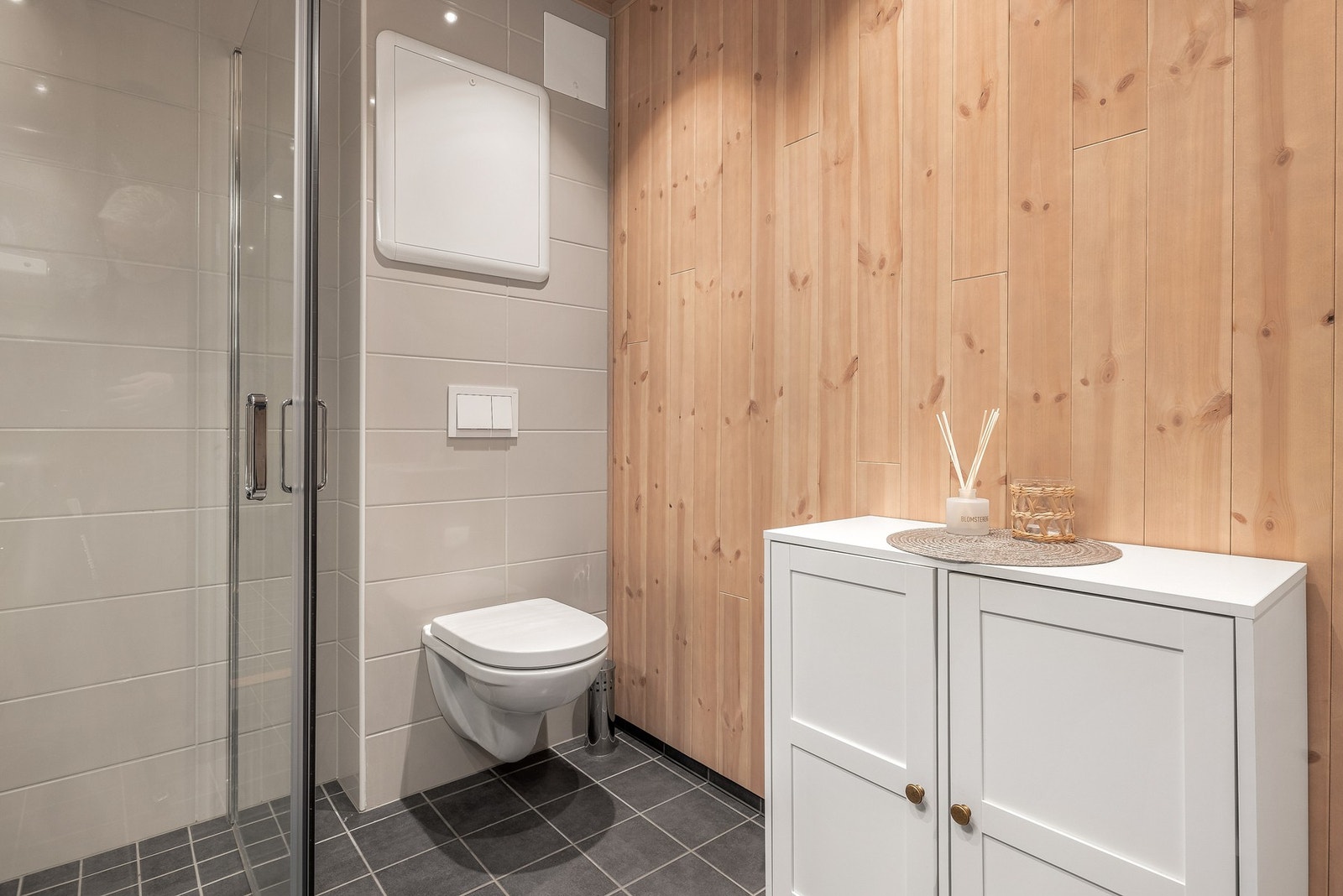 Innfellbare dusjdører, vegghengt toalett og baderomsinnredning Galleribilde