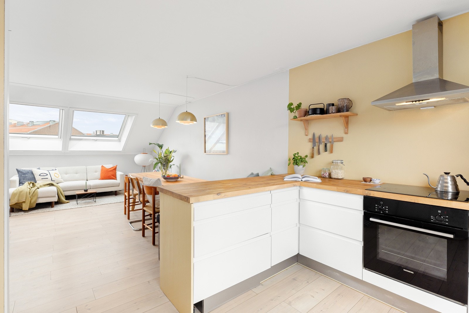 Den åpne løsningen mellom stuen og kjøkkenet gir en sosial og åpen atmosfære - perfekt for samvær med familie og venner. Galleribilde