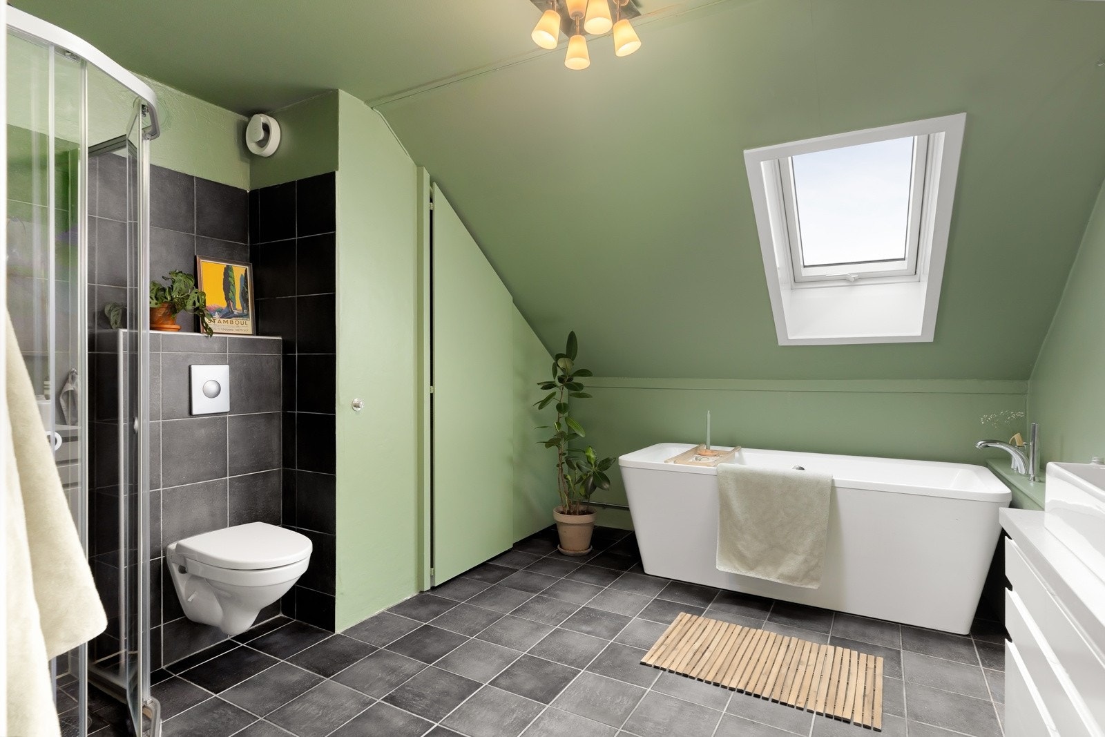 Badet er romslig og har både dusj, badekar og plassbygget skap for vaskemaskin og tørketrommel. Galleribilde