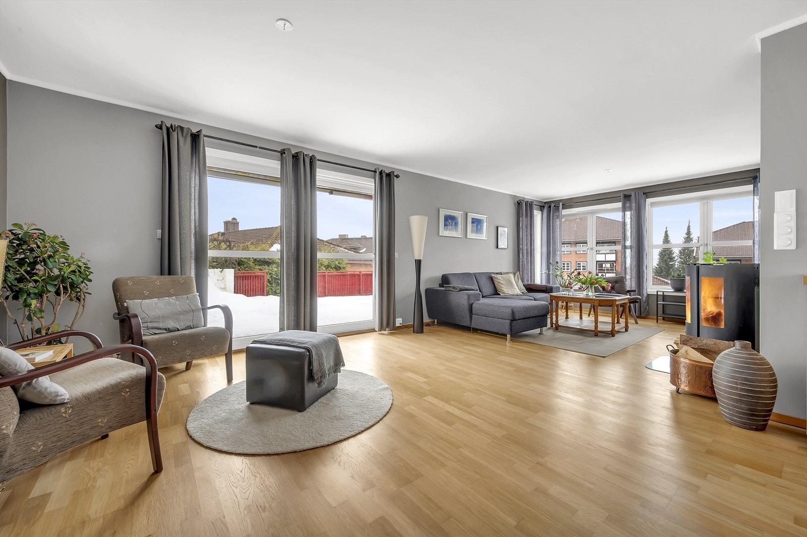 Lys og innbydende stue med mye naturlig lysinnslipp fra store vindusflater Galleribilde