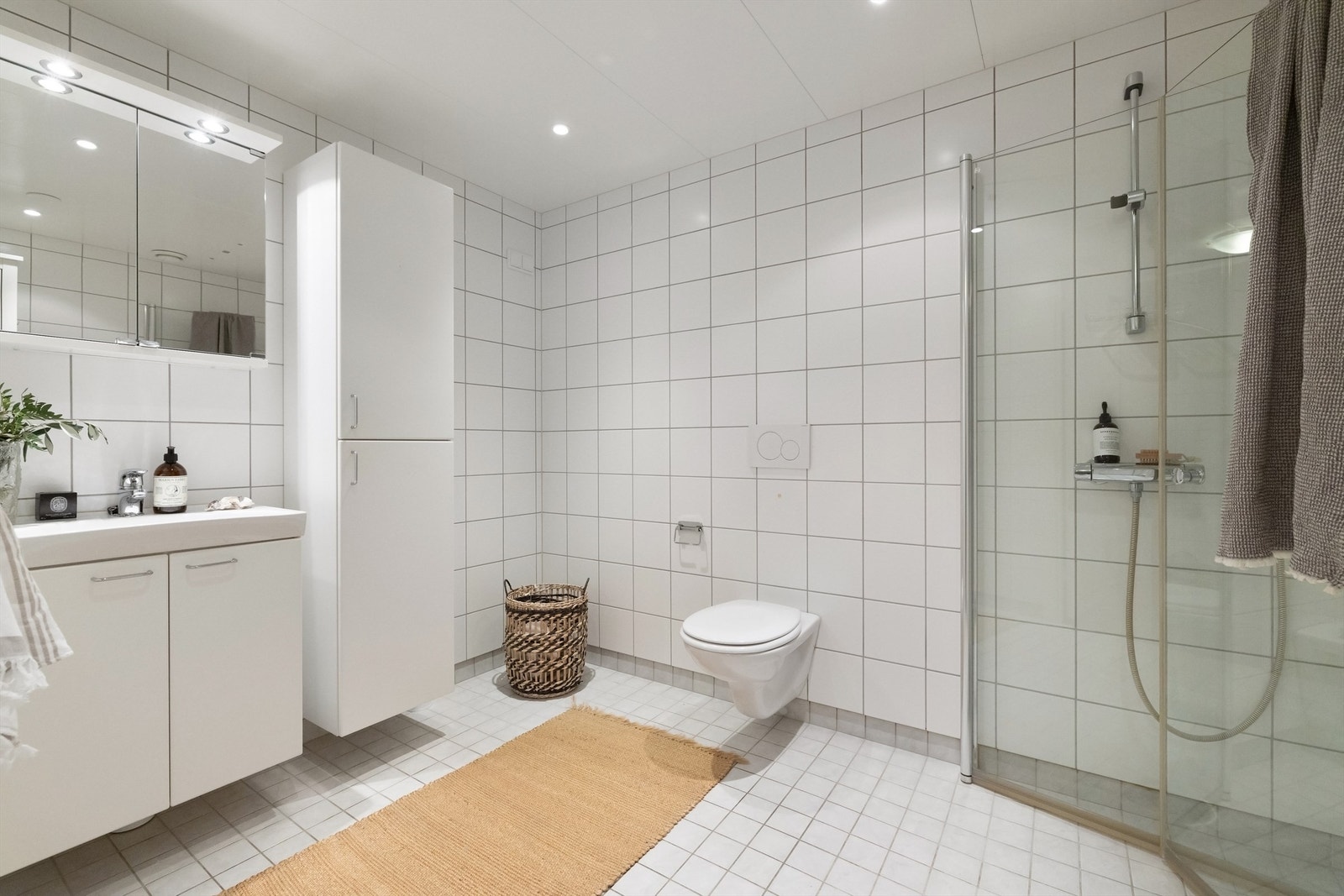 Et pent, flislagt bad med varme i gulv og nedsenket himling av metall plater og downlights. Opplegg og plass for vaskemaskin og tørketrommel Galleribilde