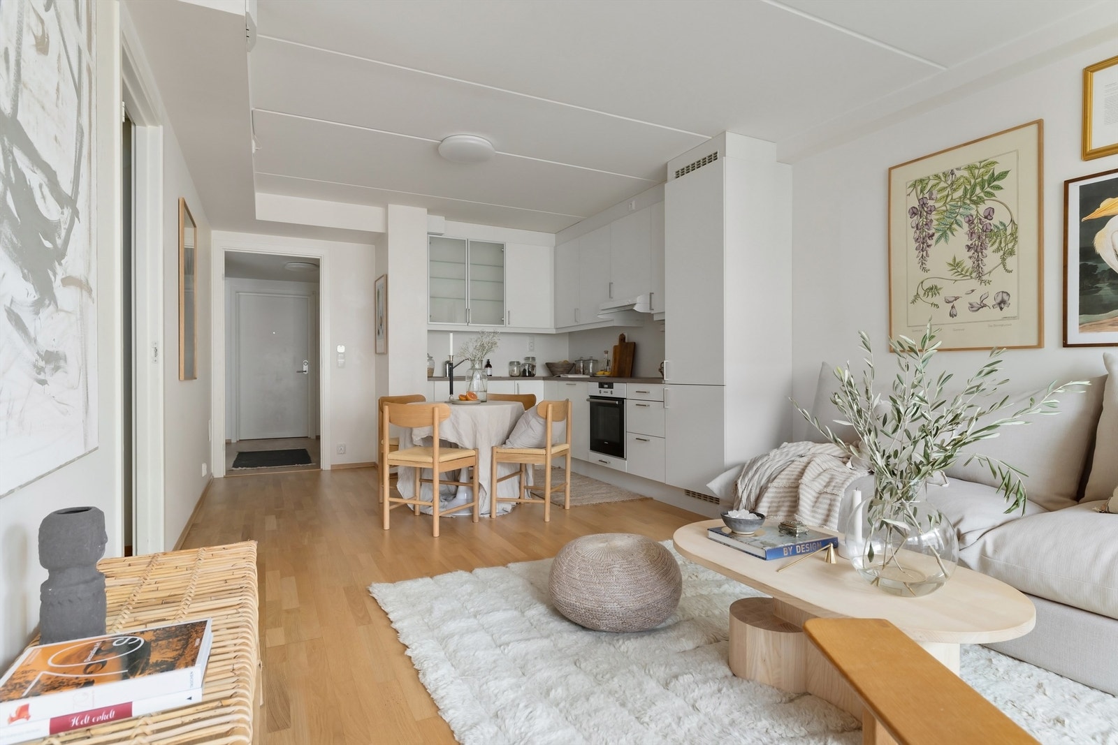 Åpen stue/kjøkkenløsning malt i lyse farger og gulvflater belagt med parkett Galleribilde