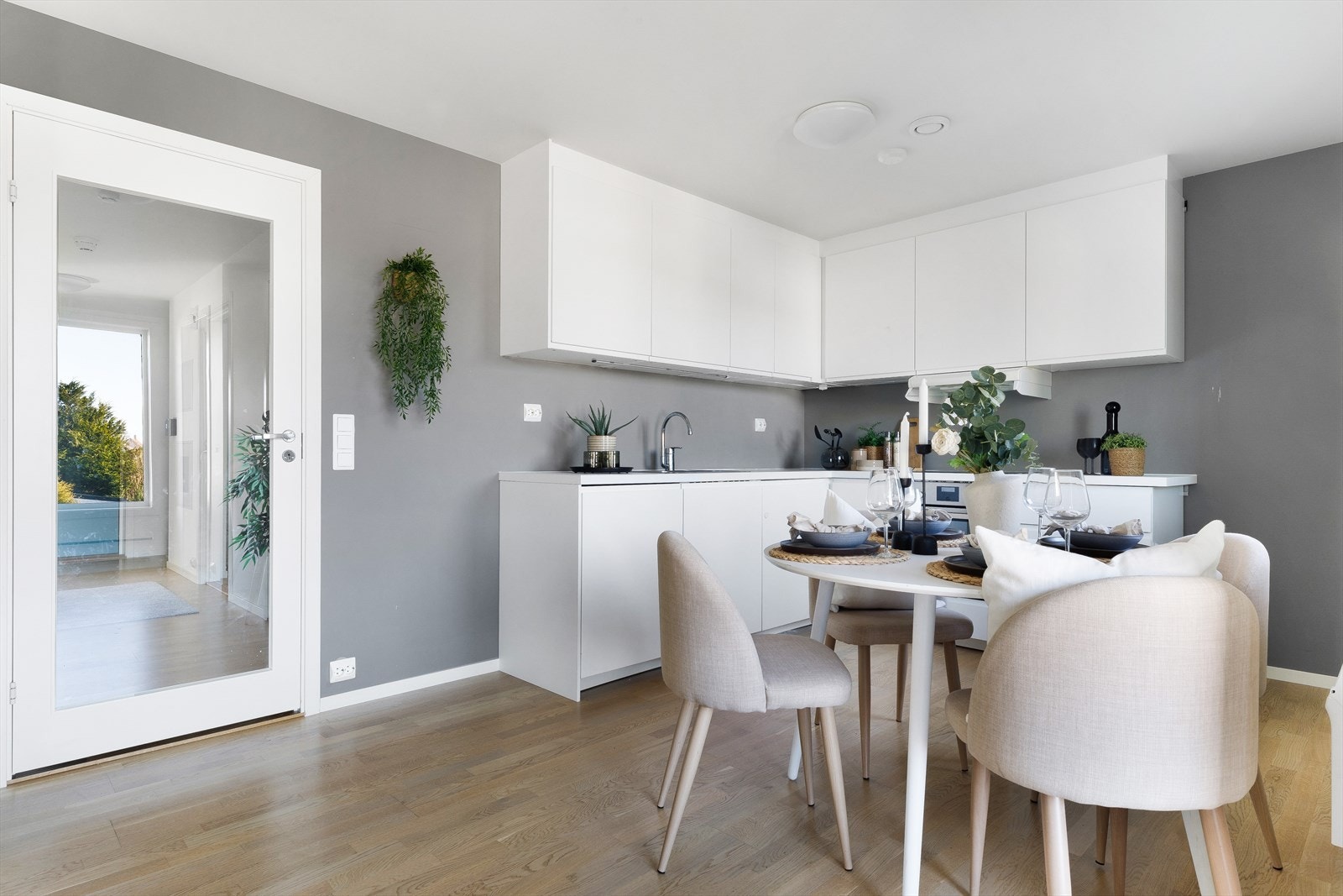 Kjøkkenet har tidløs innredning med slette, hvite fronter og benkeplate av laminat. Galleribilde