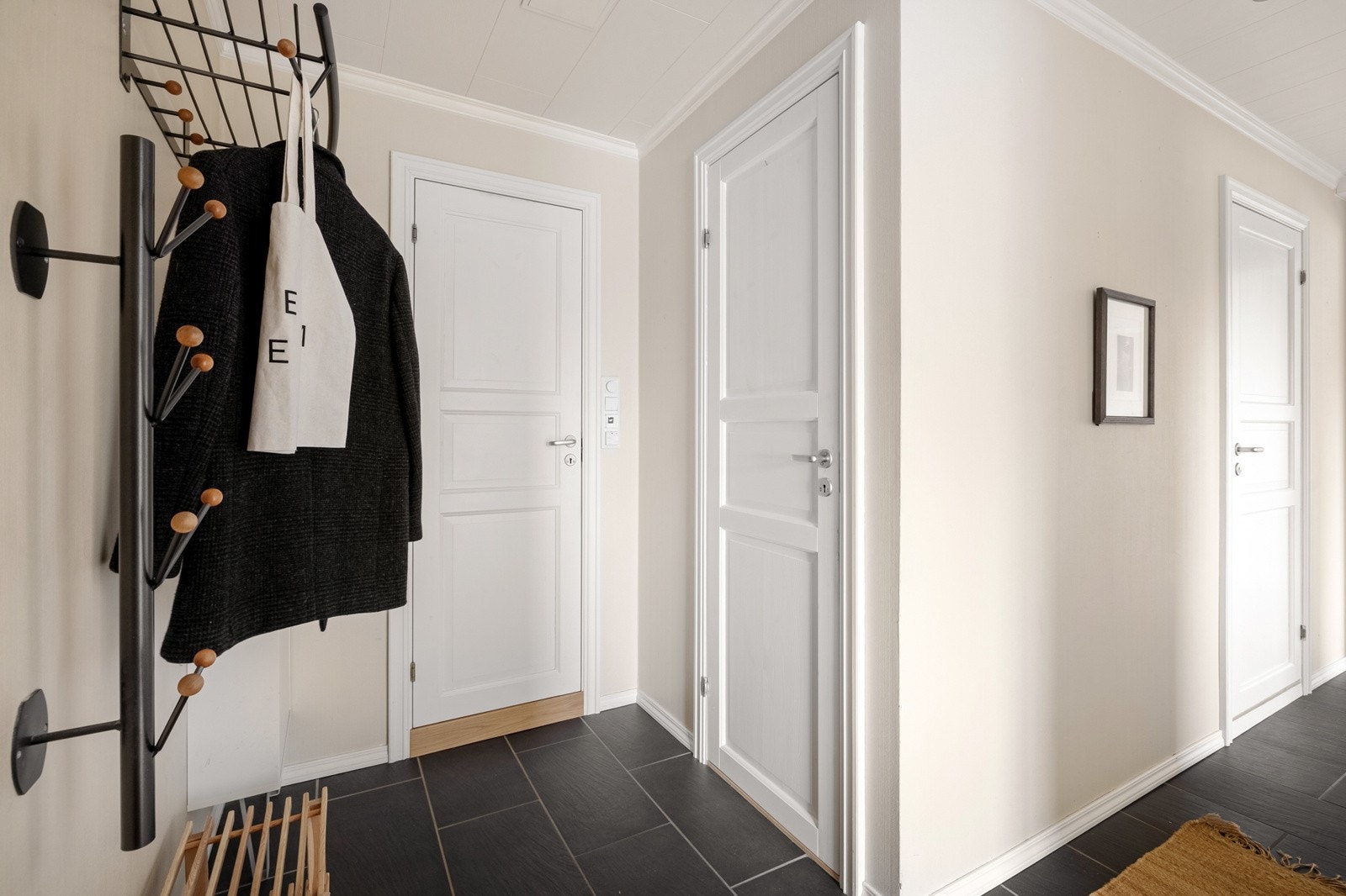 Velkommen inn, romslig entré med plass til å henge av seg yttertøyet. Det er fliser på gulv samt varmekabler. Galleribilde