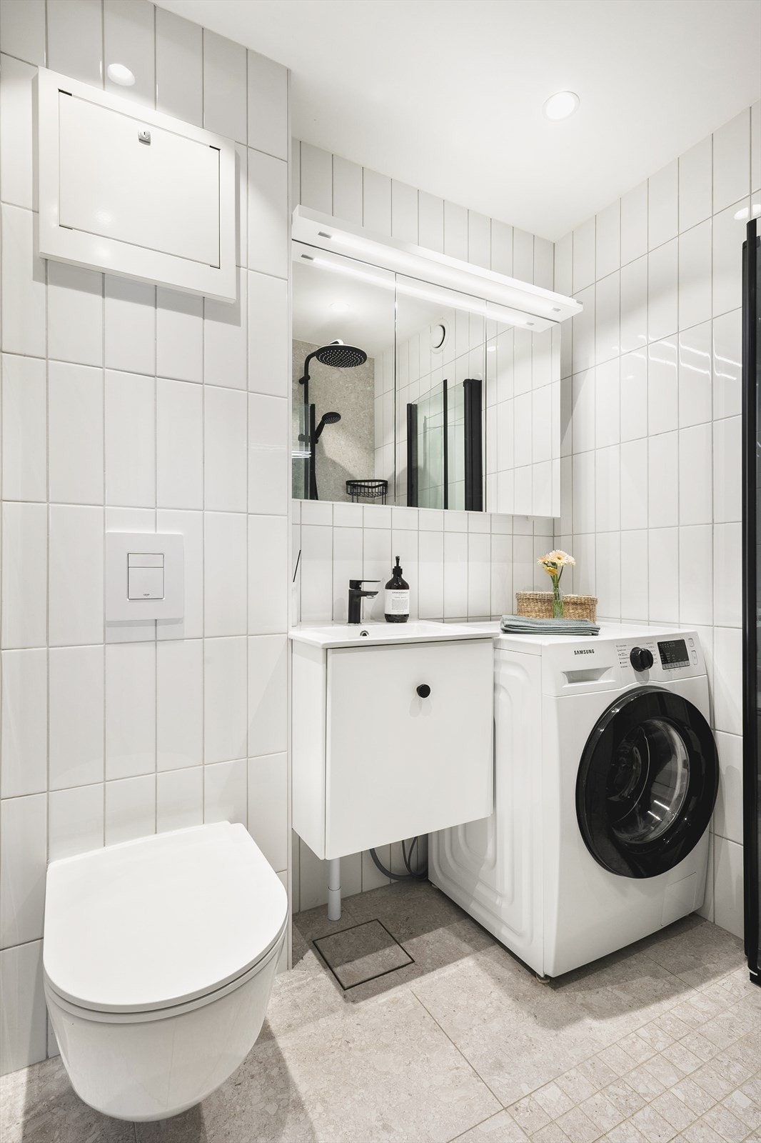 Rommet har tidsriktige farge- og materialvalg med flislagte overflater, innfelte downlights i himling og behagelig gulvvarme. Det er mye oppbevaringsplass i speilskapet. Galleribilde