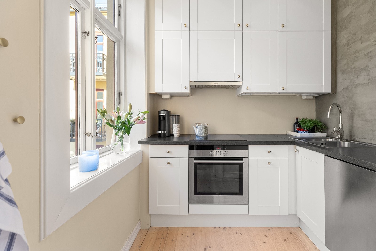 Separat kjøkken med stort vindu ut mot bakgård Galleribilde