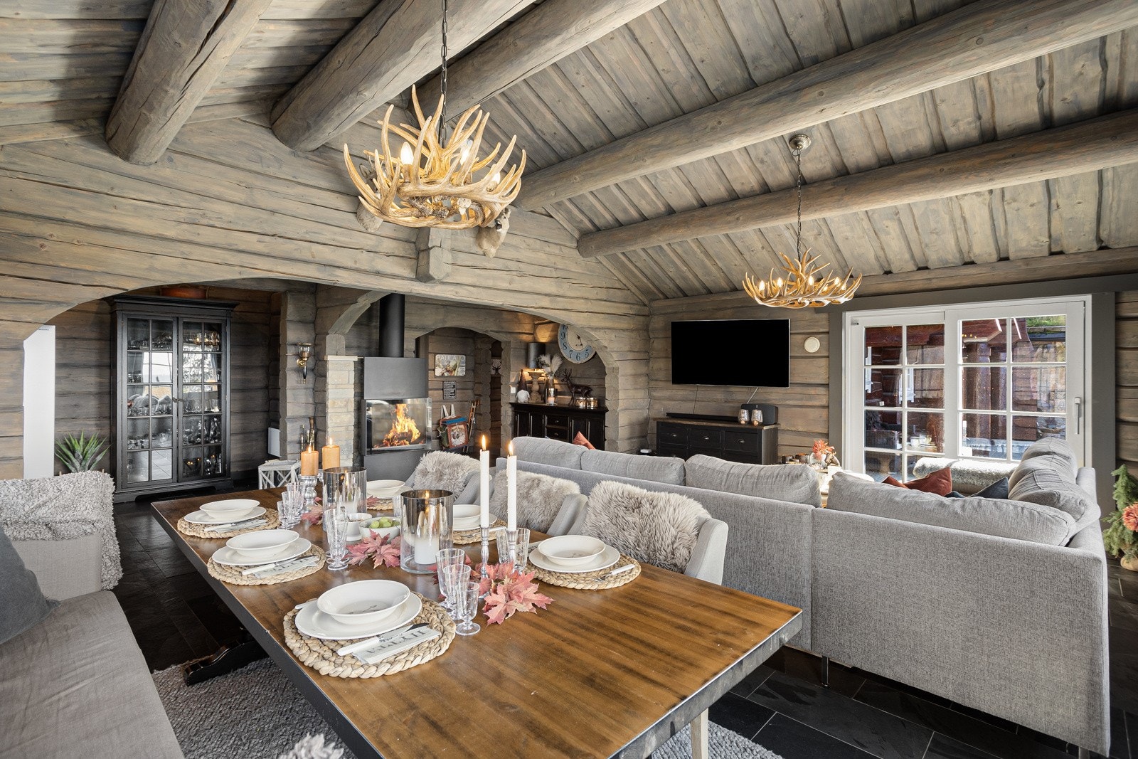 Flott stue med en eventyrlig peis som setter hyttestemningen på fjellet Galleribilde